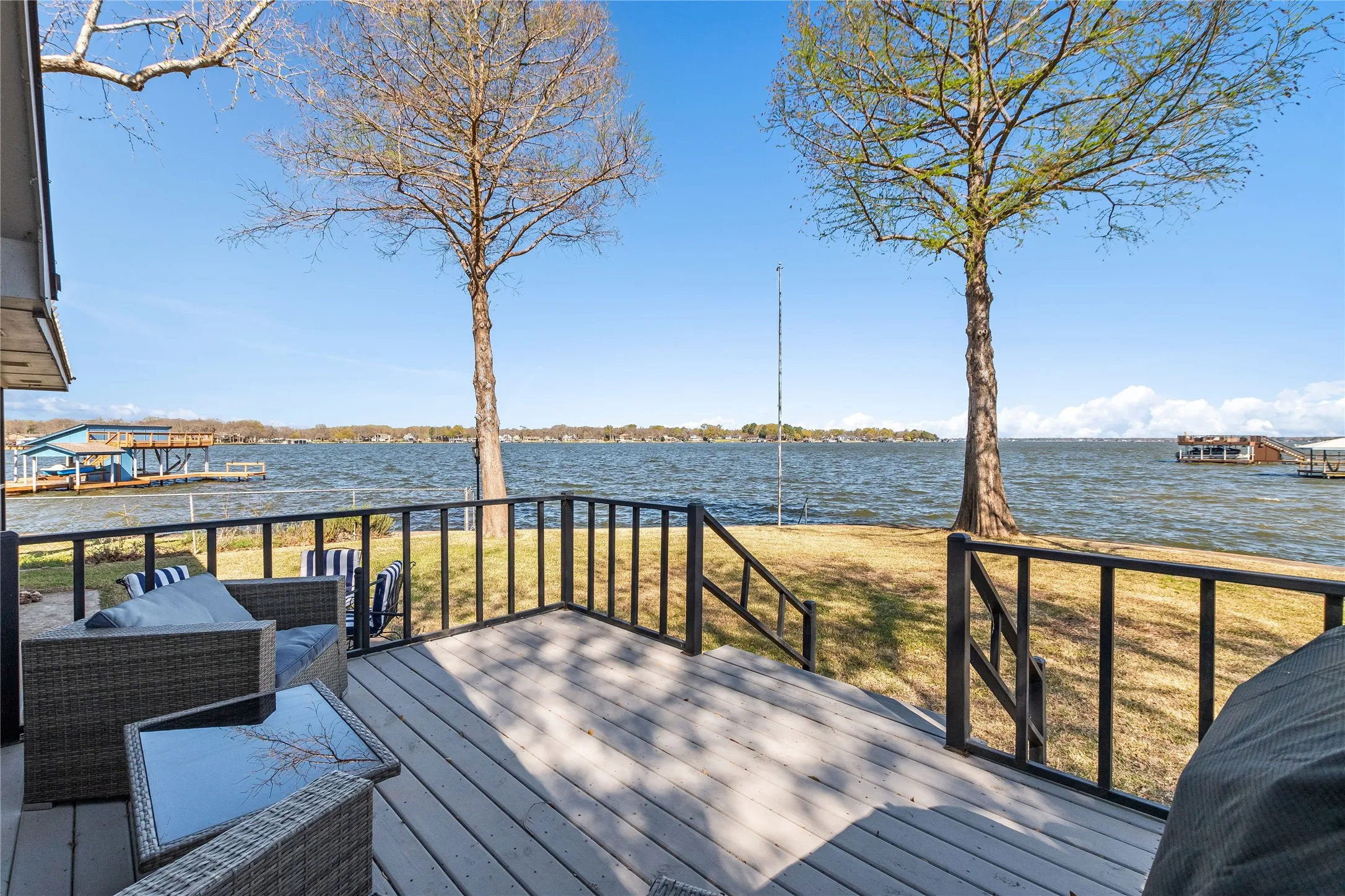 Wooden deck with a water view and a yard