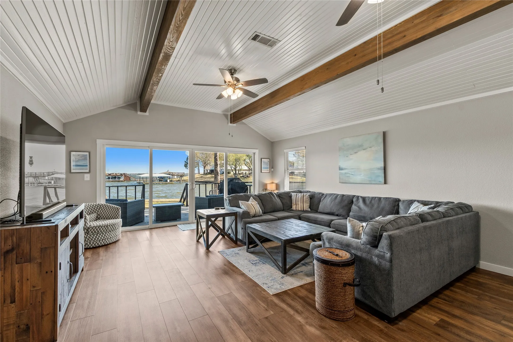 Living room with a water view, a ceiling fan, and dark wood-style floors