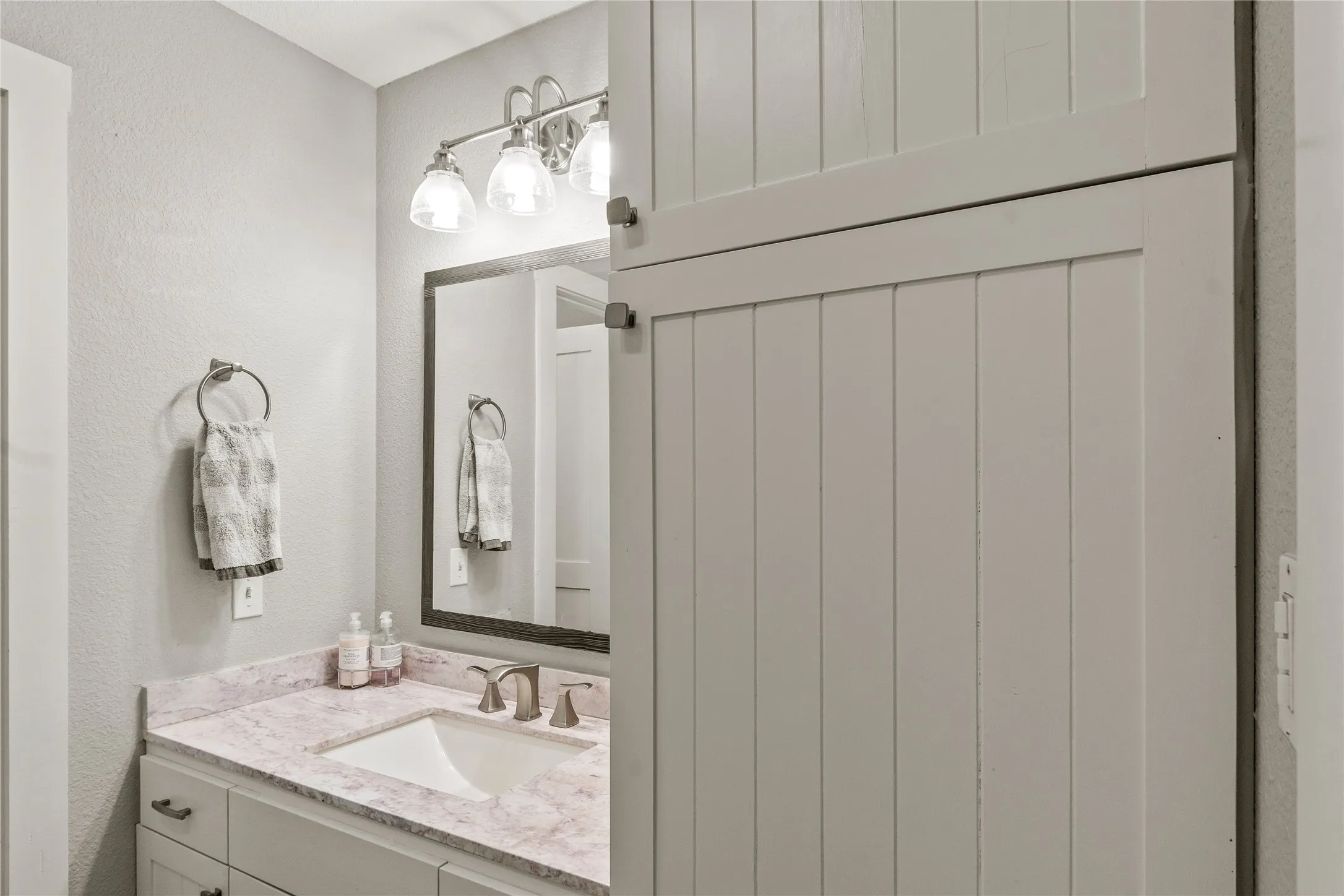 Bathroom featuring vanity and a textured wall