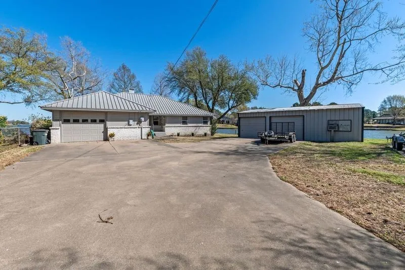Single story home with a garage, a metal roof, and an outdoor structure
