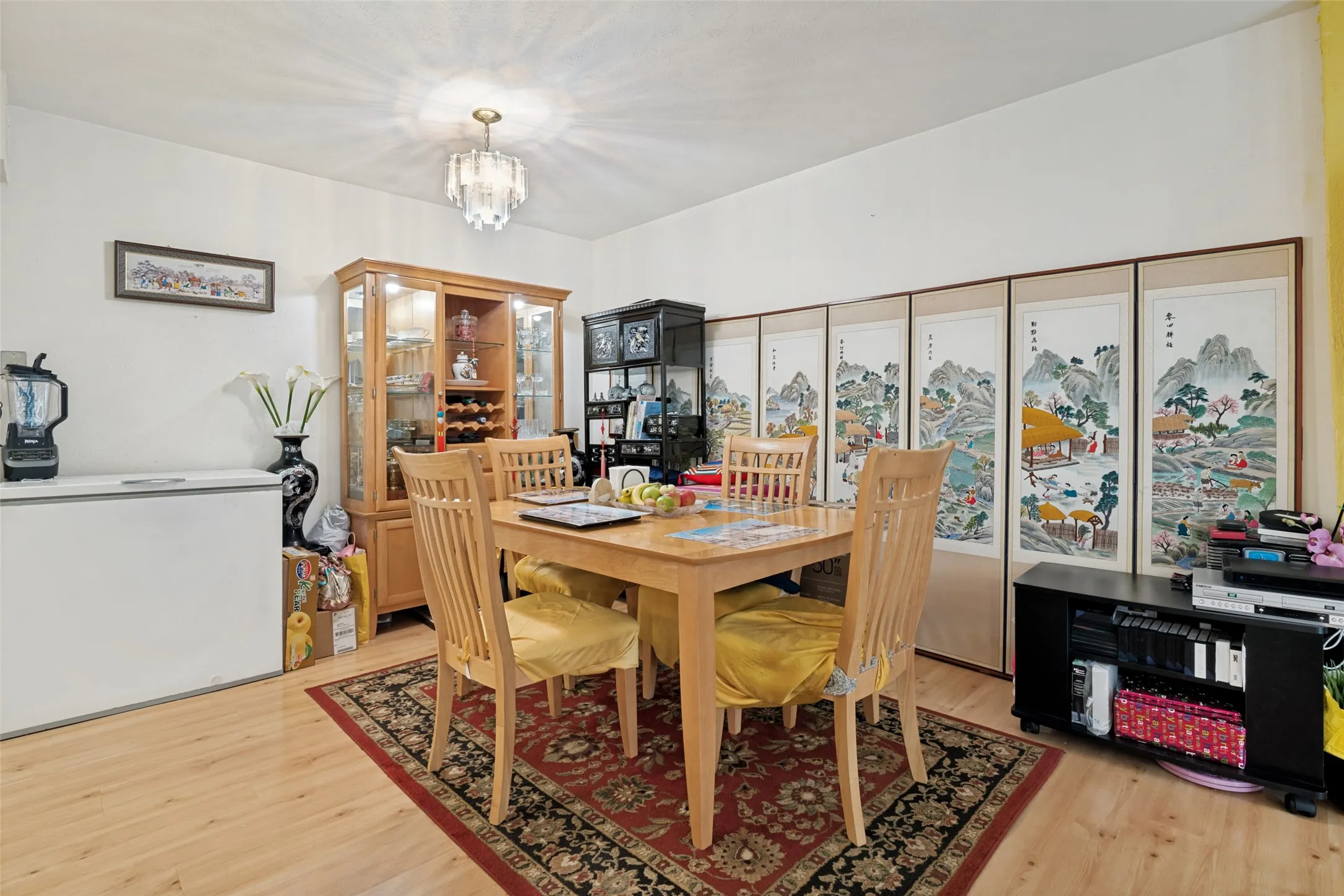 Dining area featuring wood-finish flooring and a central chandelier