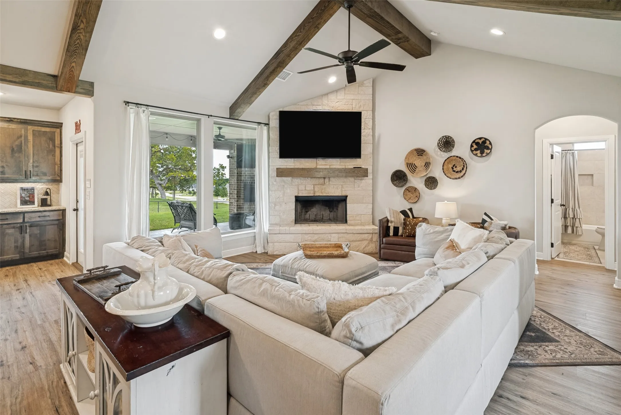 Inviting stone fireplace and floor to ceiling windows make this space cozy and bright