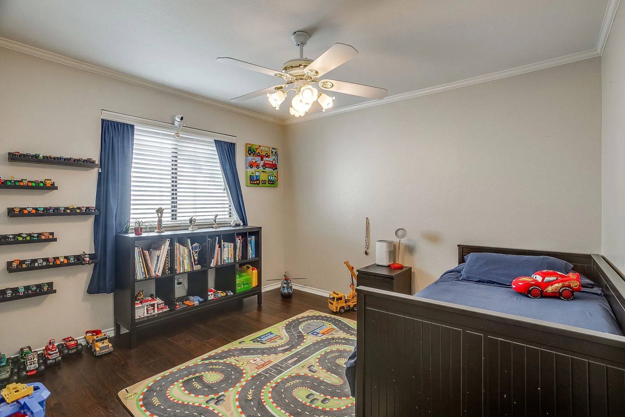 Room featuring wood flooring, a ceiling fan with integrated lighting, and crown molding