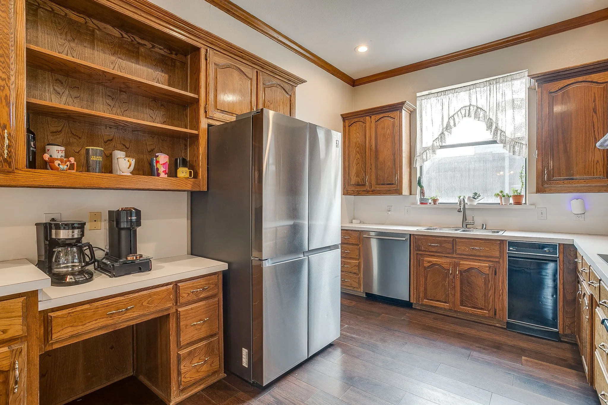 Kitchen featuring wood cabinetry, light-toned countertops, a stainless steel appliances and wood flooring