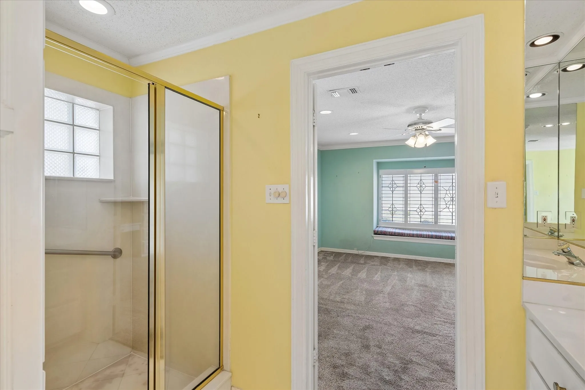 Shower with a gold-tone framed glass enclosure and white tile surround