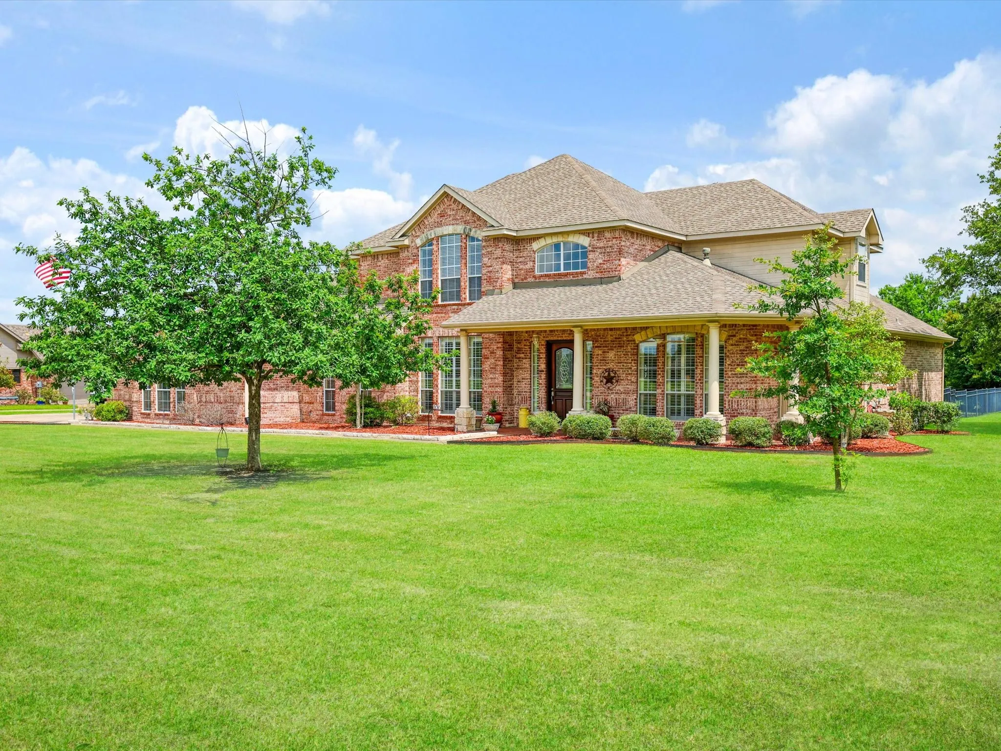 Brick exterior with multiple gables and a covered front porch featuring white columns