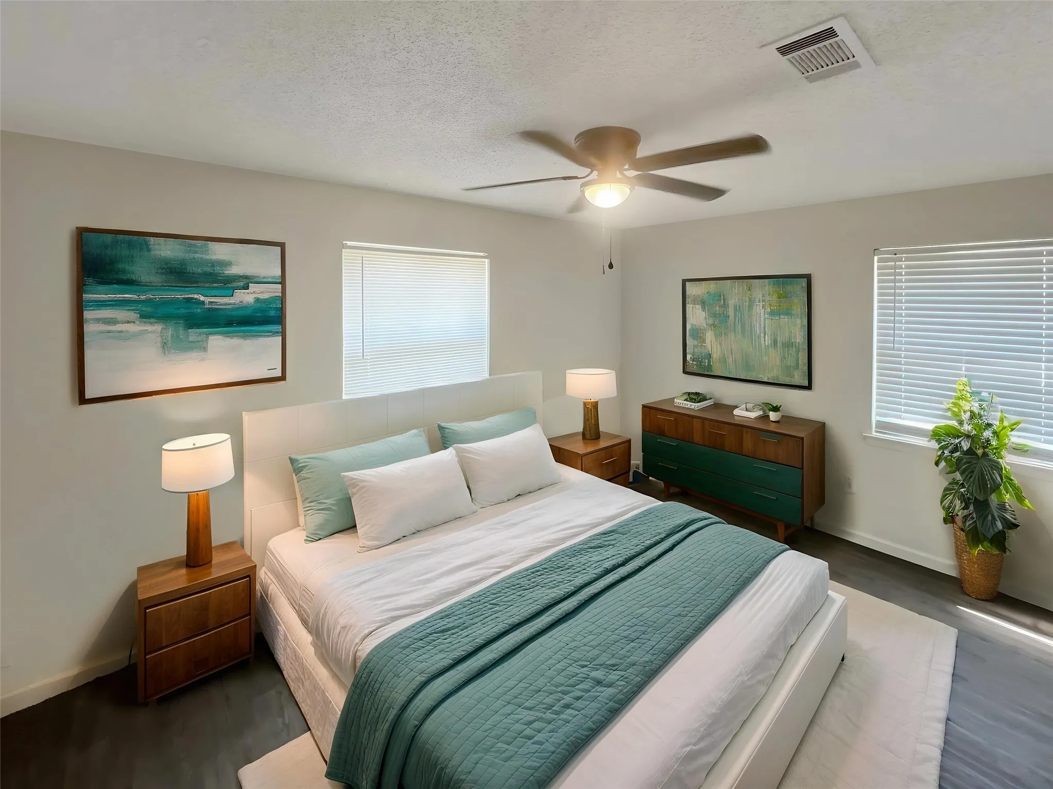 Virtually staged - Spacious room featuring ceiling fan with integrated lighting, dark wood-finish flooring, and white window blinds