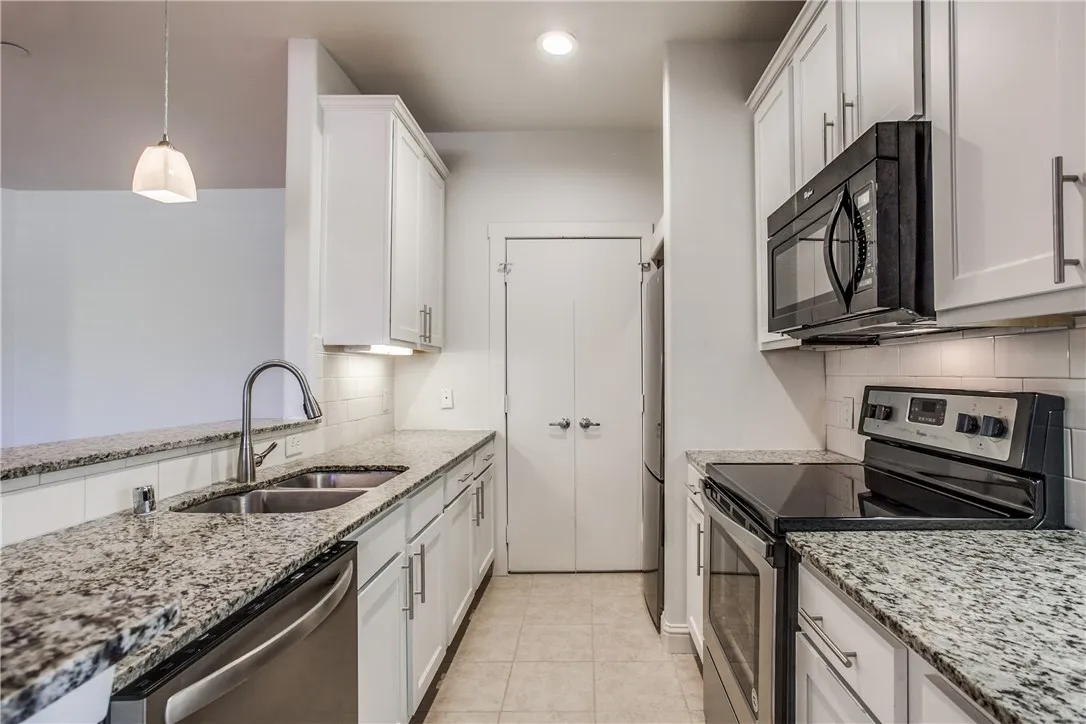 Granite countertops, stainless steel appliances, updated cabinetry and sleek backsplash add style to this home