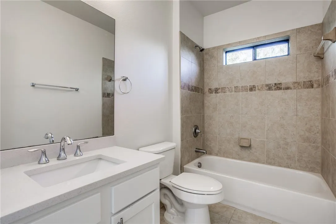 Second bath with updated cabinetry and tile surround tub/shower combo.