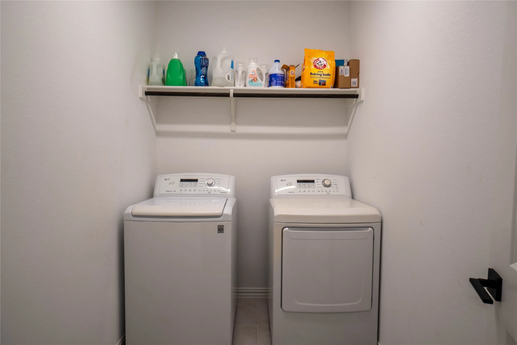 Dedicated laundry area featuring a white top-load washing machine and front-load dryer