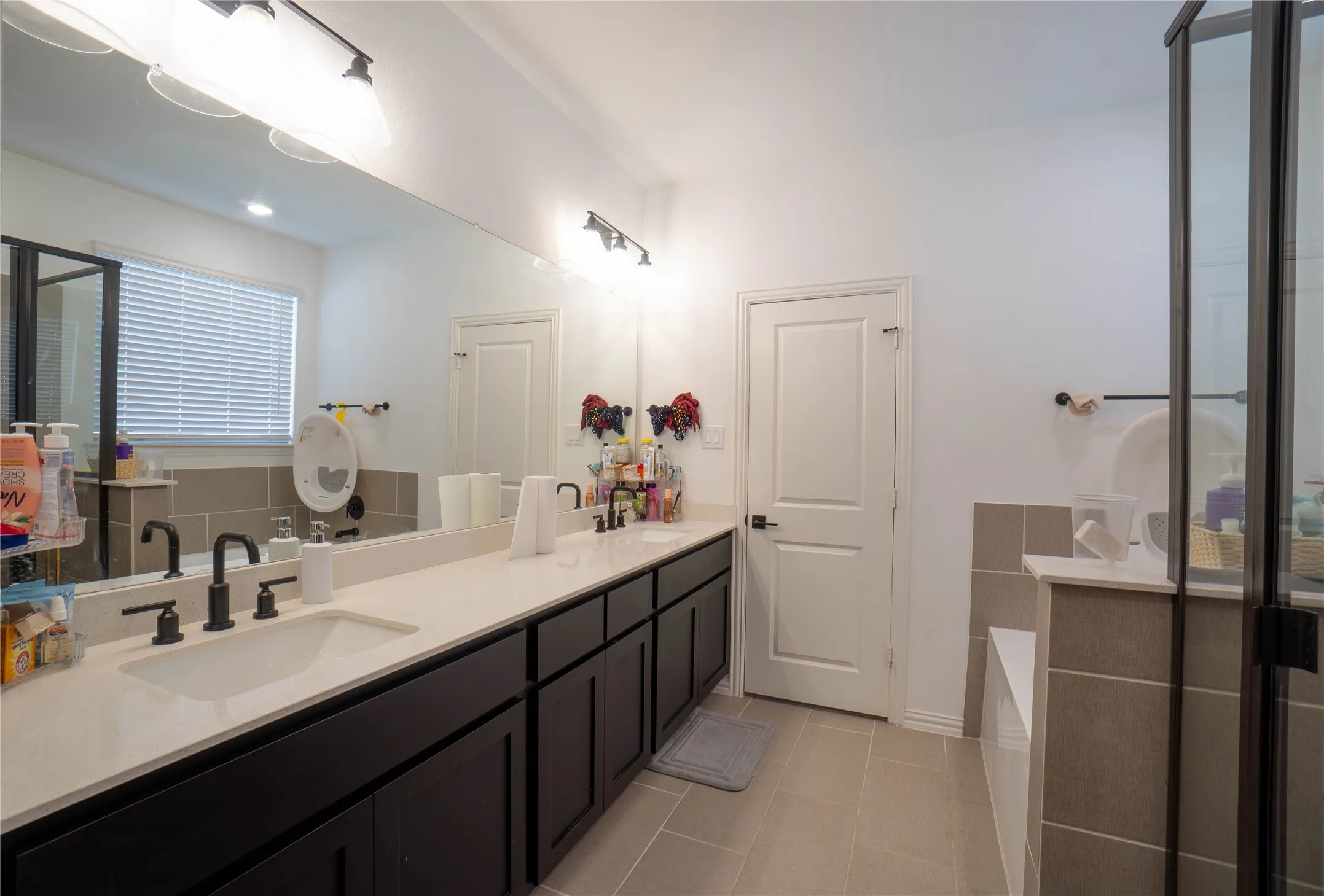 Double vanity with integrated sinks, quartz countertop, and matte black fixtures