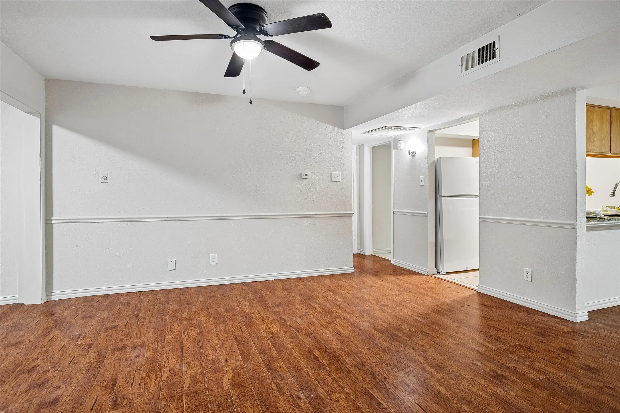 Living Room has great wall space for art and furniture. View toward kitchen and 2nd full bath.