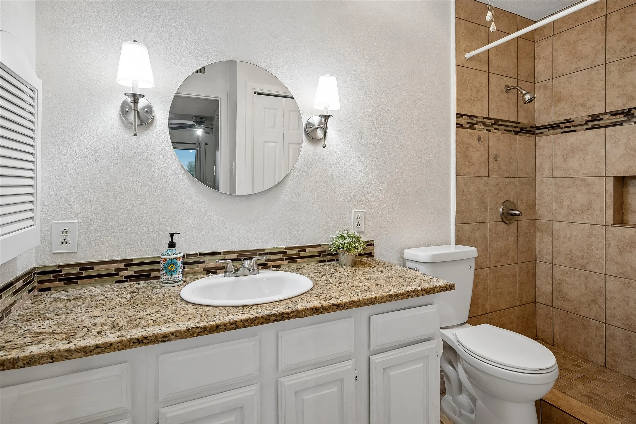 Primary Bath with granite vanity top, ceiling fan, medicine cabinet, linen closet and pretty walk-in shower