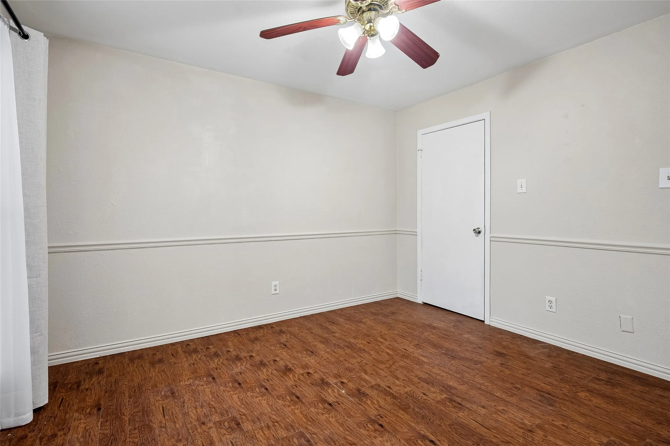 Second Bedroom also has pretty laminate wood flooring, chair rail and ceiling fan