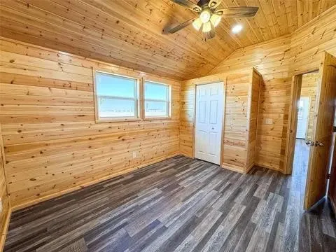Interior room featuring wood-plank walls and a vaulted wood-plank ceiling