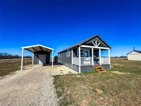 Compact home featuring a covered front porch with white railing, blue siding, and white trim accents