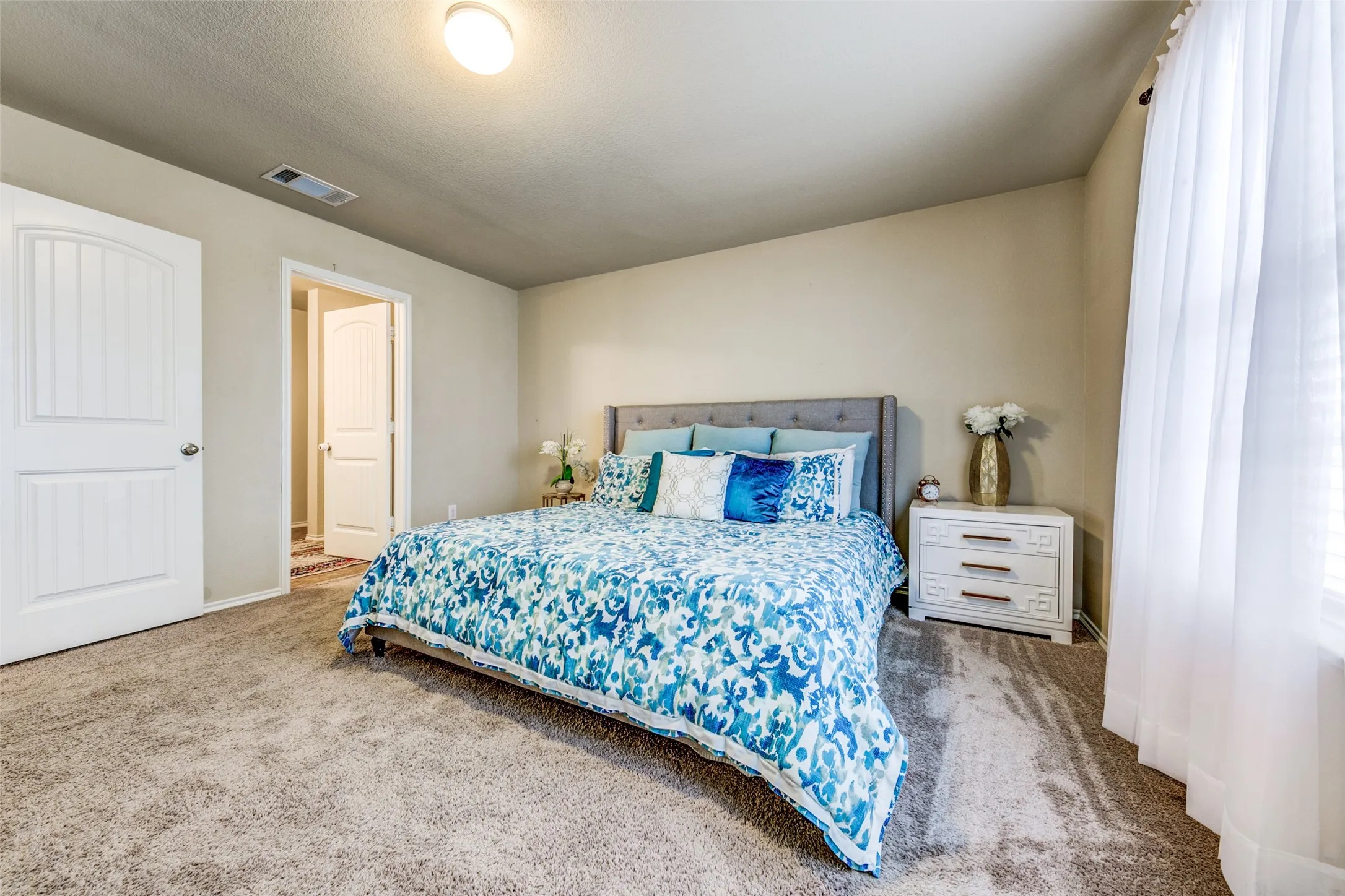 Carpeted bedroom featuring neutral walls and a ceiling light fixture