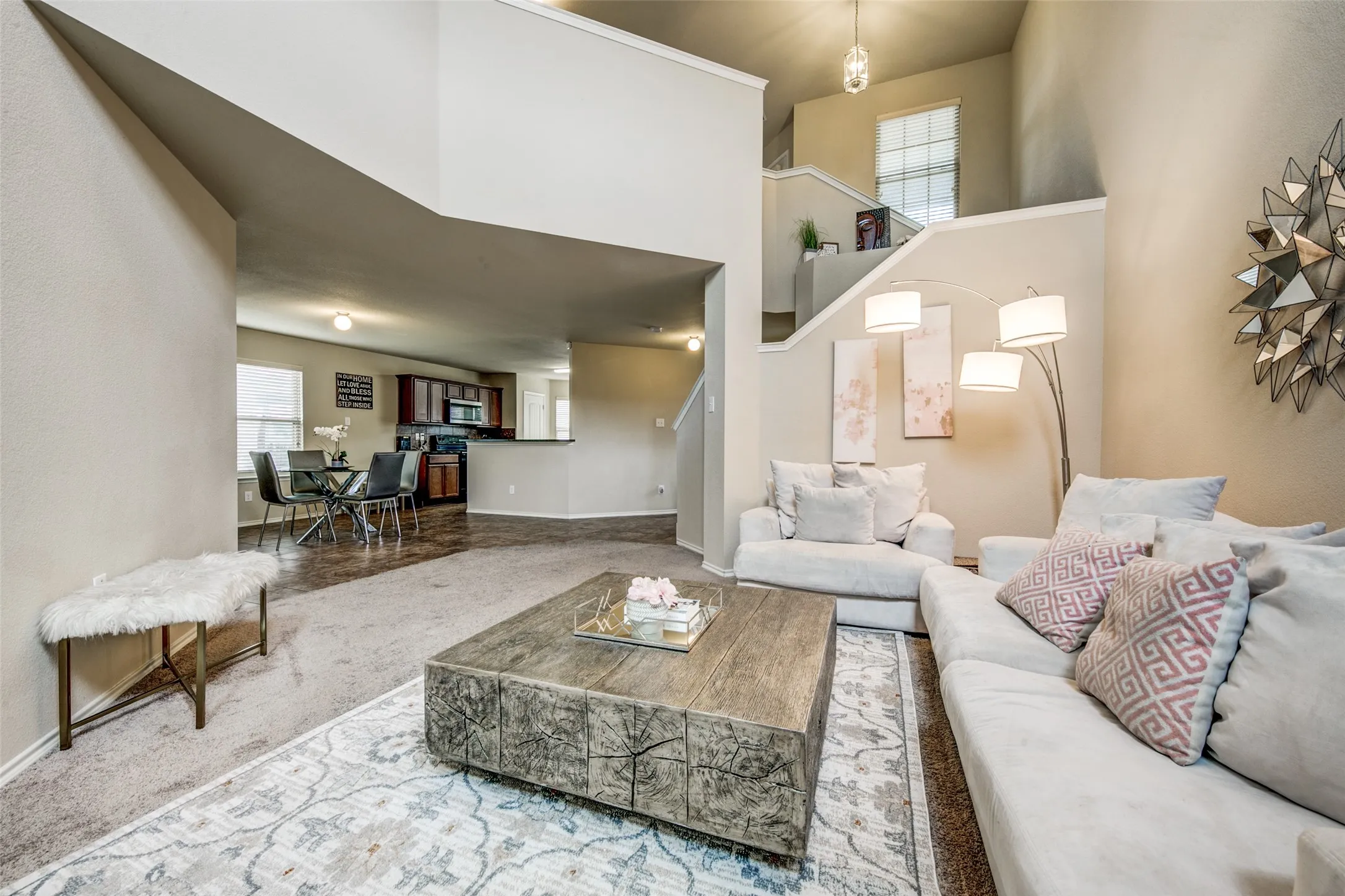 Living area featuring a high ceiling, a staircase with a landing, and carpet flooring