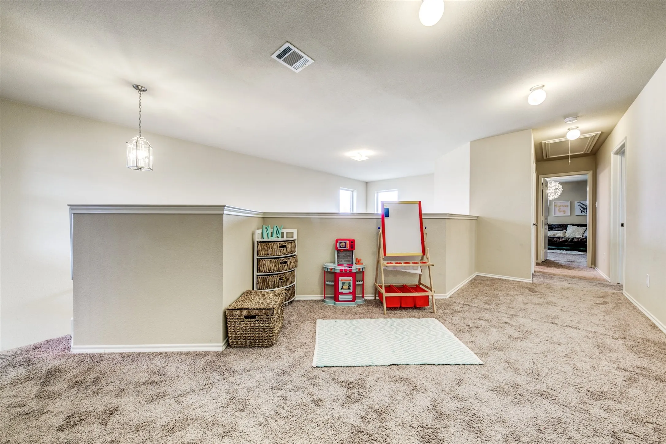 Carpeted open-concept loft space with vaulted ceilings