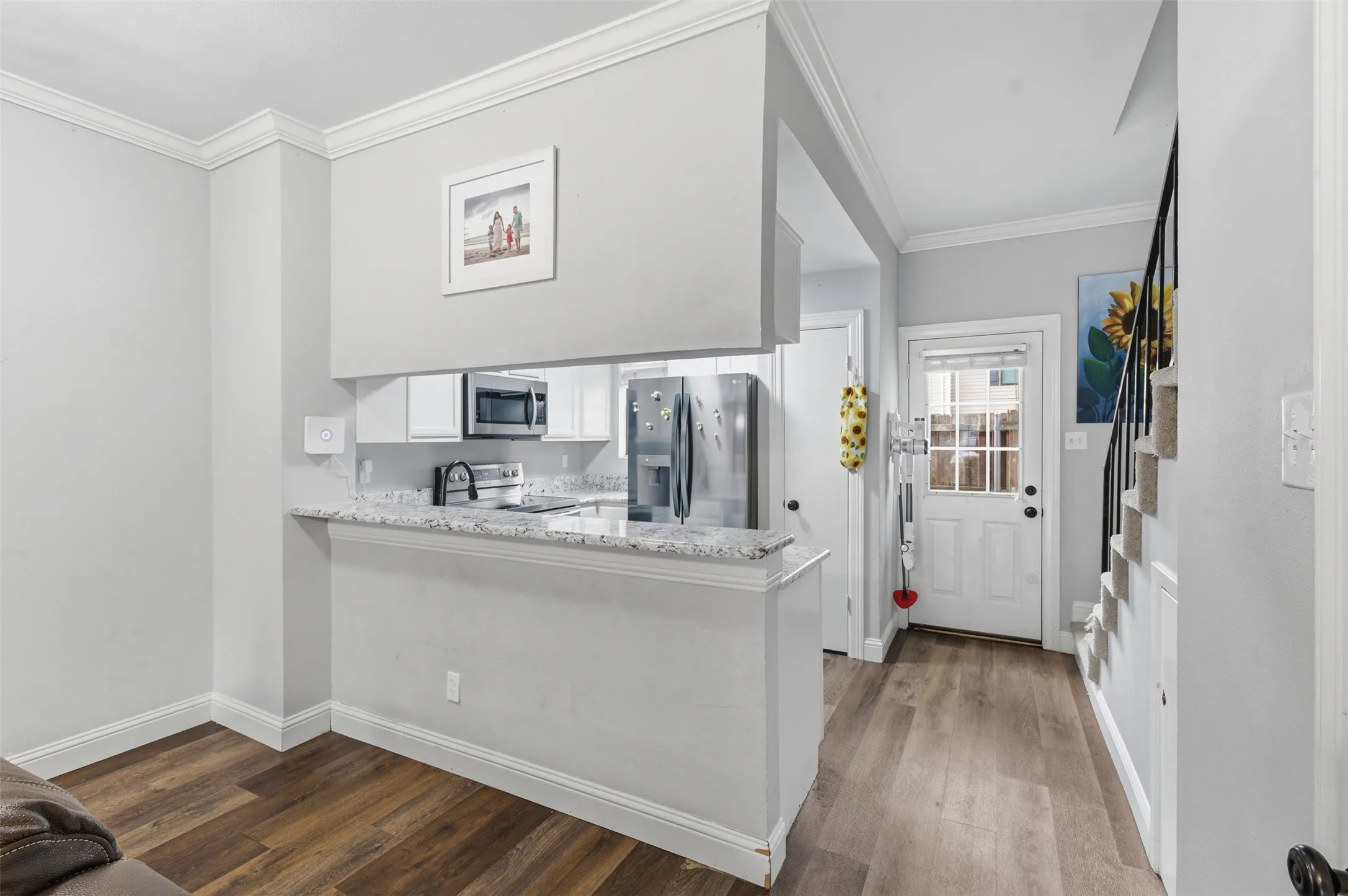 Kitchen pass-through featuring stone countertops and stainless steel appliances