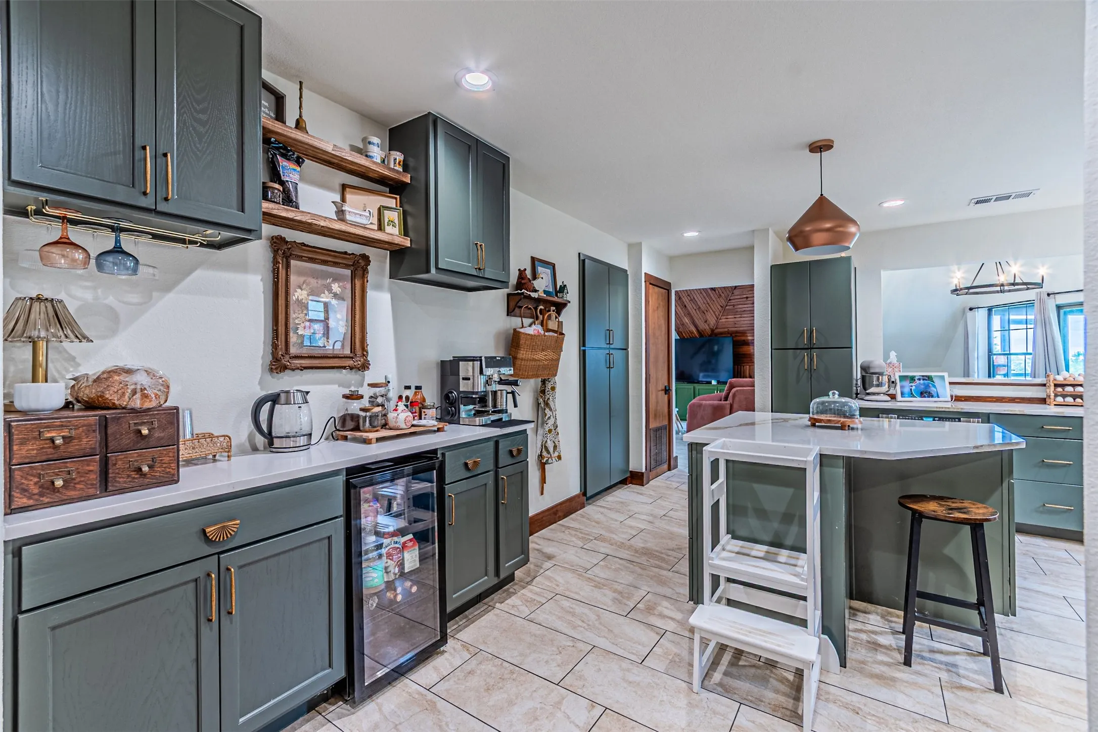 Modern kitchen featuring dark green cabinetry, white countertops, and tile flooring