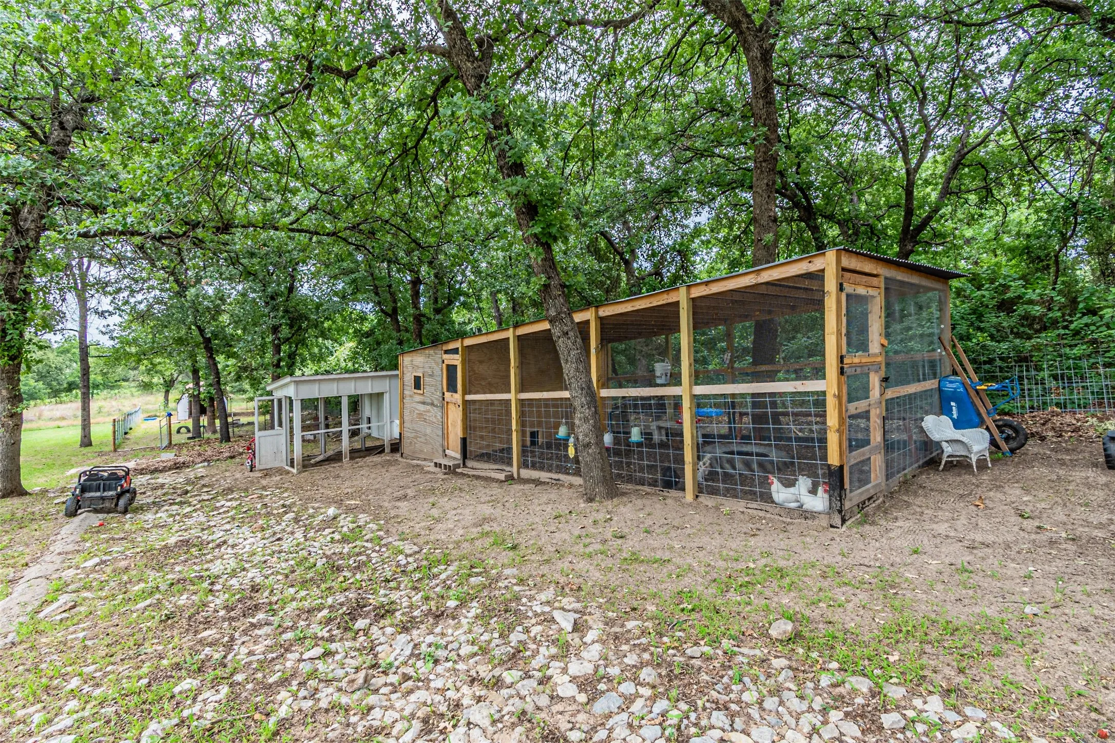 Outdoor animal enclosure featuring wood framing, wire mesh, and a corrugated roof