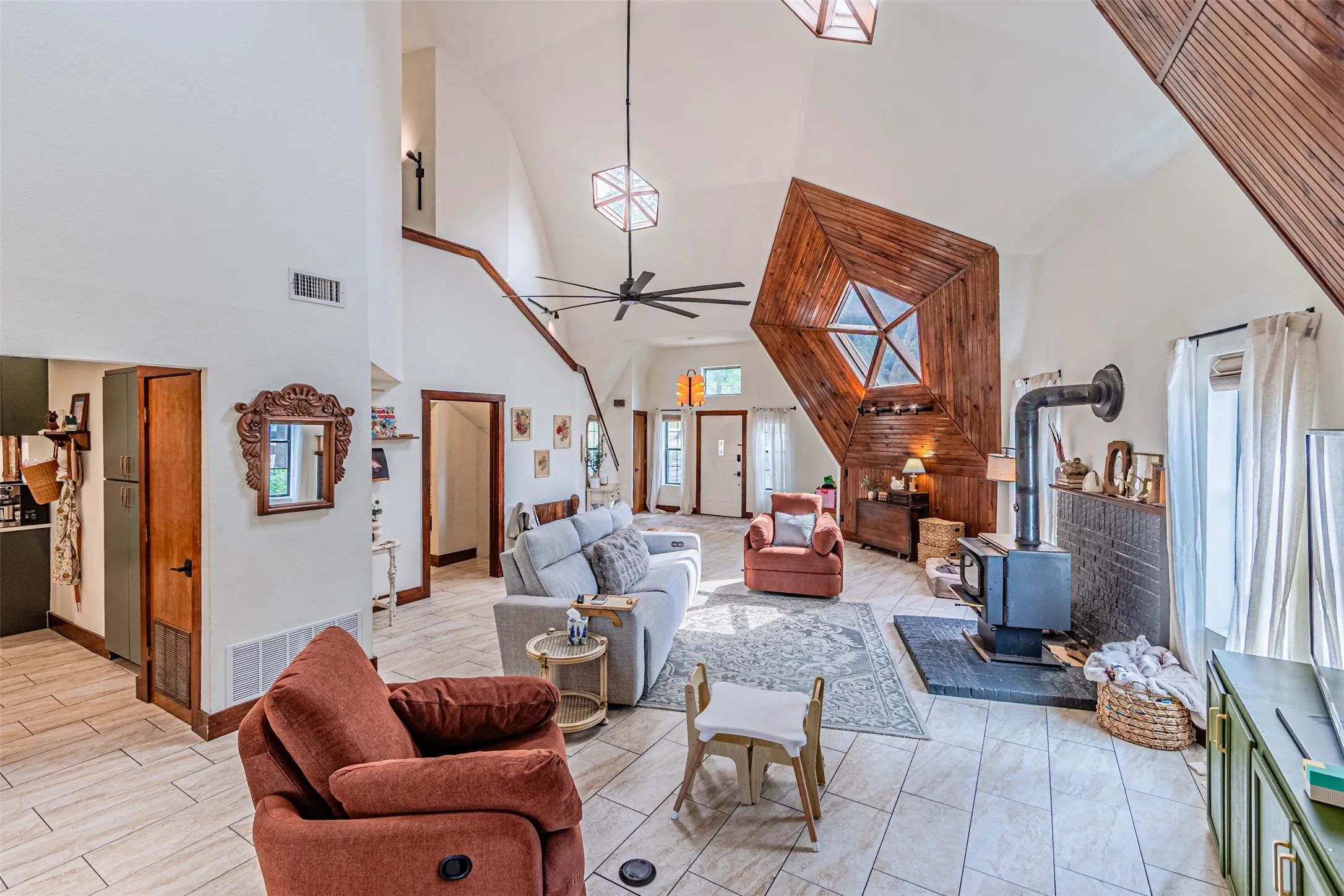 Vaulted ceilings featuring exposed wood beams and a contemporary ceiling fan