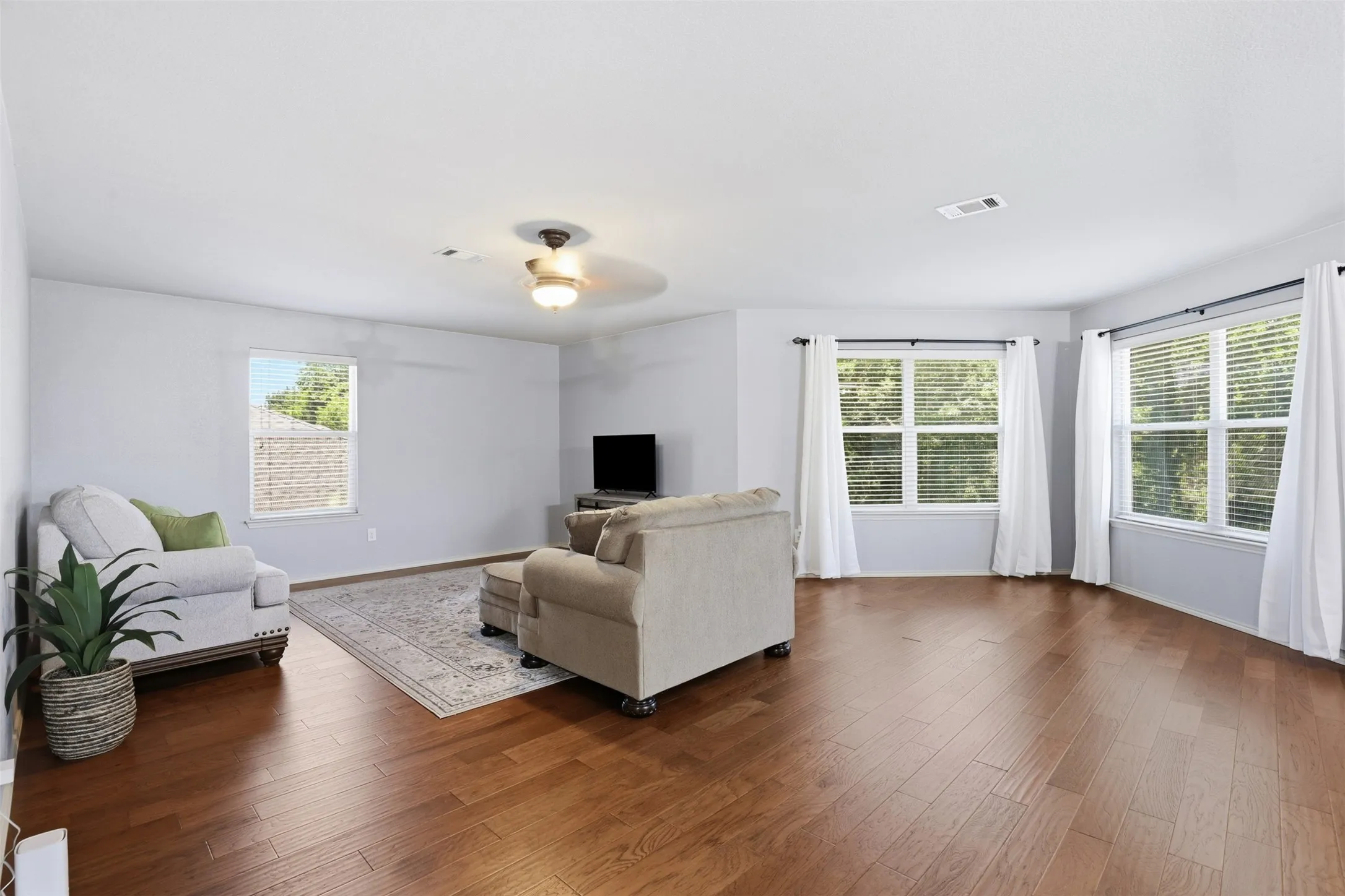 Spacious living area featuring rich wood-finish flooring throughout