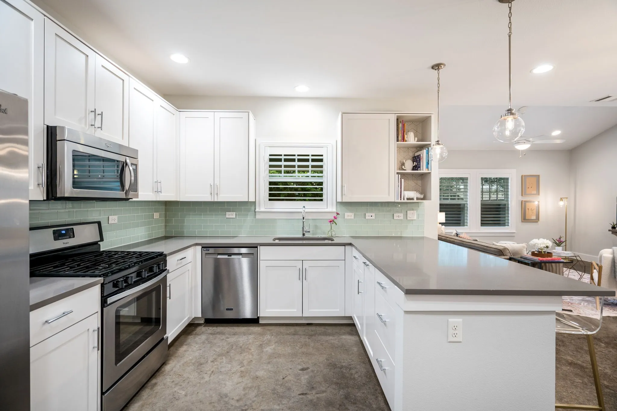     Chef-inspired kitchen with oversized island, shaker-style cabinetry, and stainless steel appliances.