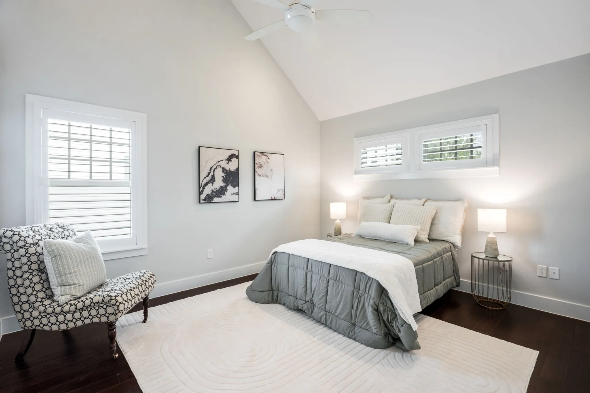     Vaulted primary suite filled with natural light and warm hardwood flooring.