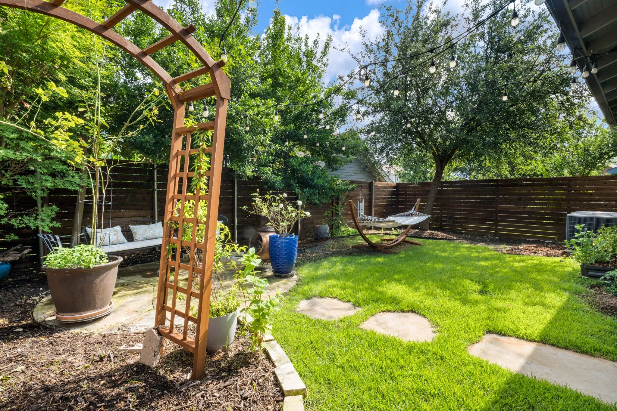     Beautifully landscaped backyard with mature trees, entertaining spaces, and serene privacy.
