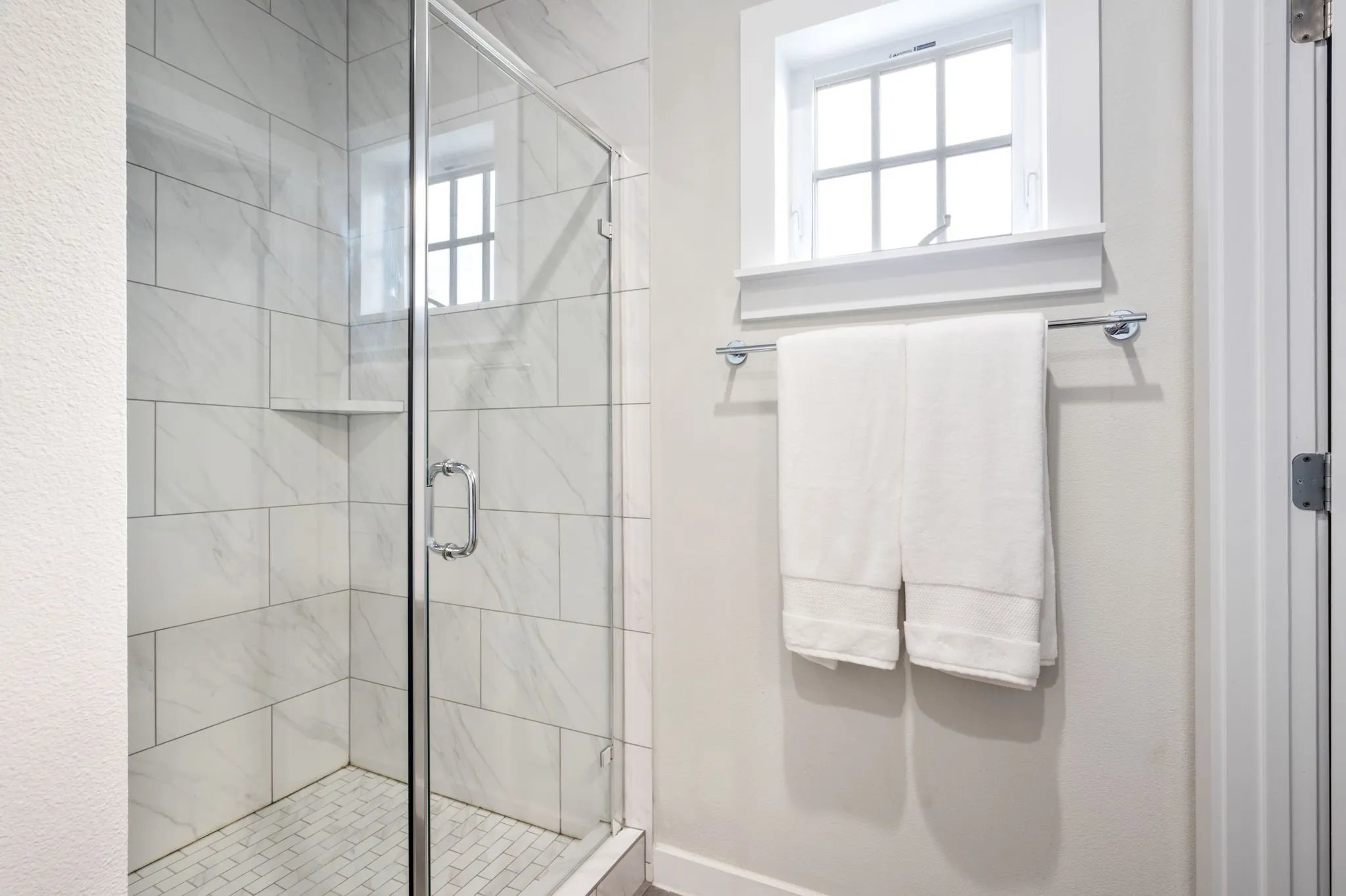     Spa-inspired walk-in shower with sleek tile surround and natural light.