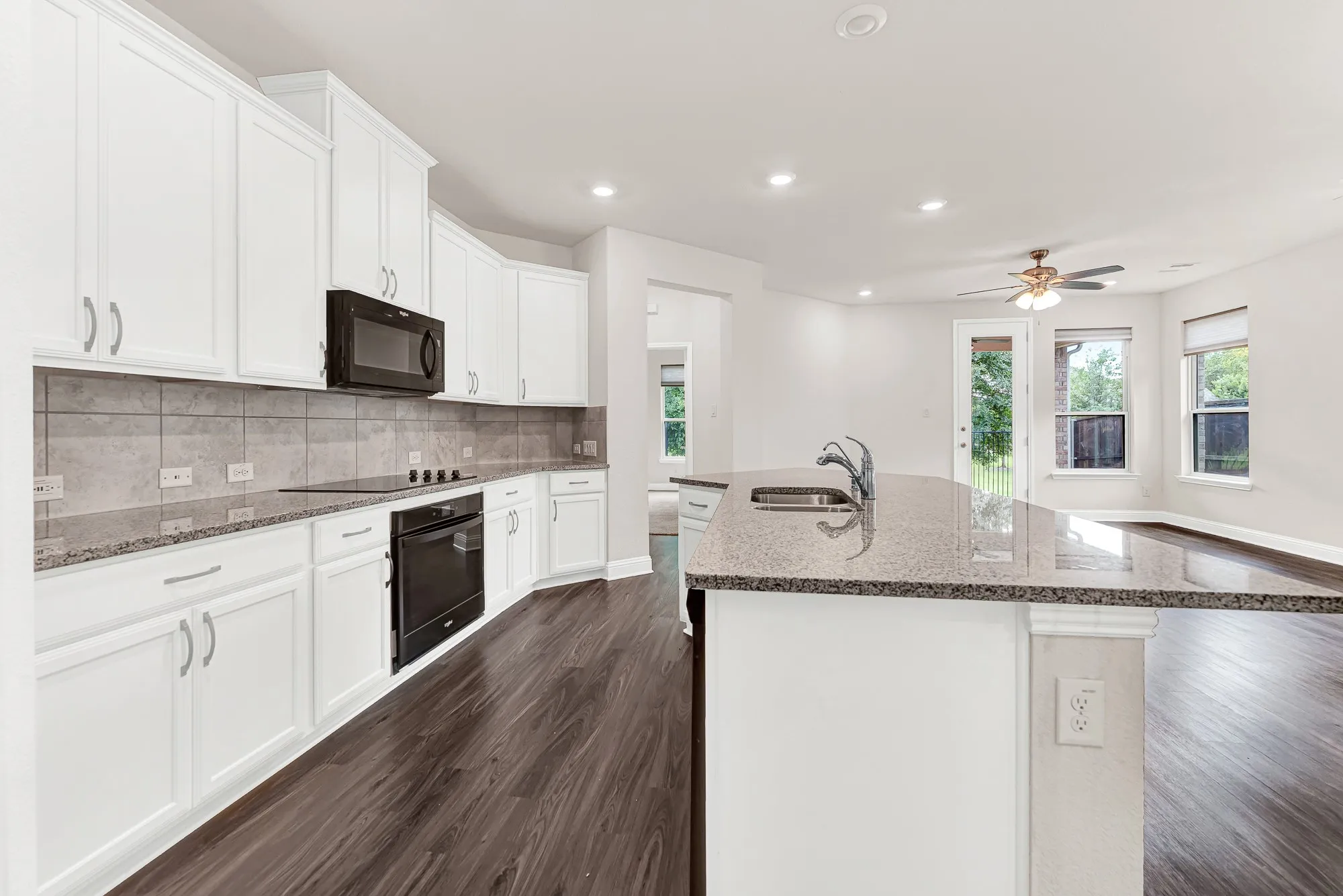 This perspective highlights how naturally the cooking zone flows into the airy, sun-washed living area beyond. Imagine standing by the sink with a morning coffee, looking out toward the backyard as the house slowly wakes up.