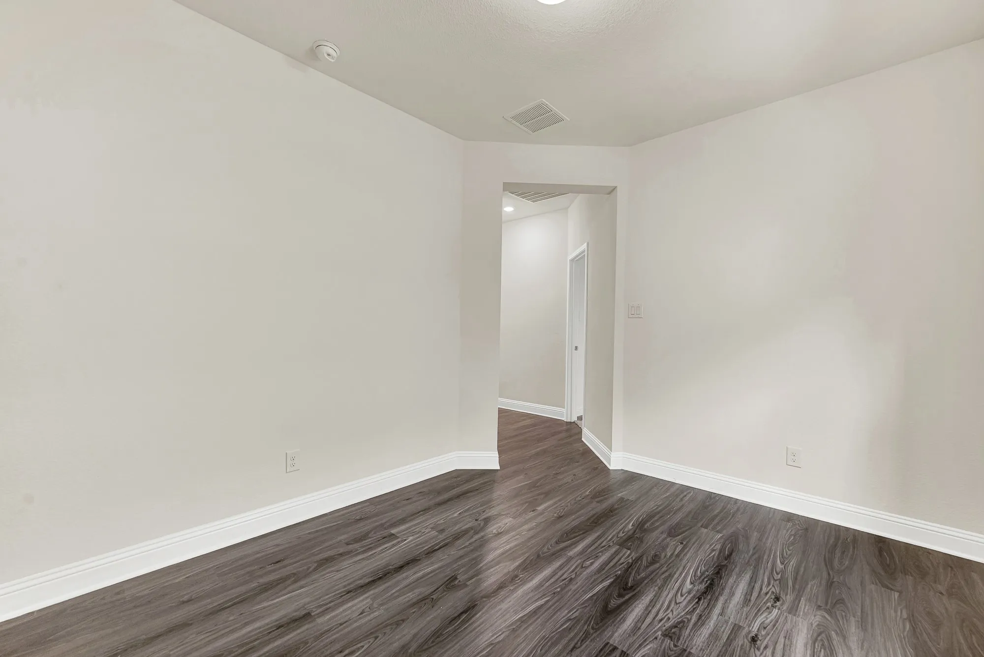 The angled entryway creates a pleasant sense of anticipation, transitioning smoothly from the main corridor into a private flex space. Picture a relaxed movie night here, winding down with family as the late-evening quiet settles over the neighborhood