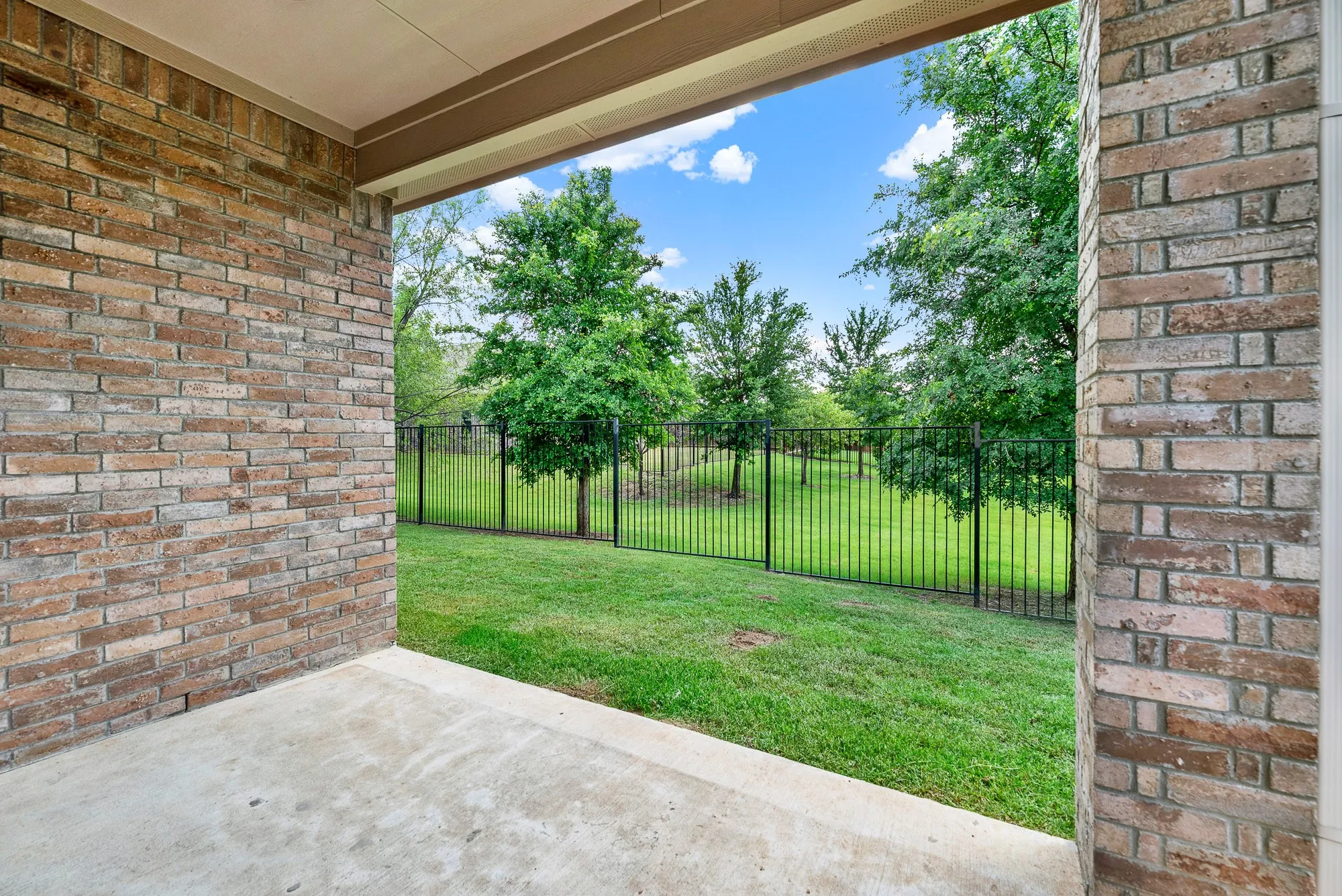 The covered patio provides a shaded sanctuary that seamlessly transitions into the open air. Imagine stepping outside with your morning espresso, enjoying the cool concrete underfoot while watching the sunrise paint the sky above the greenbelt.