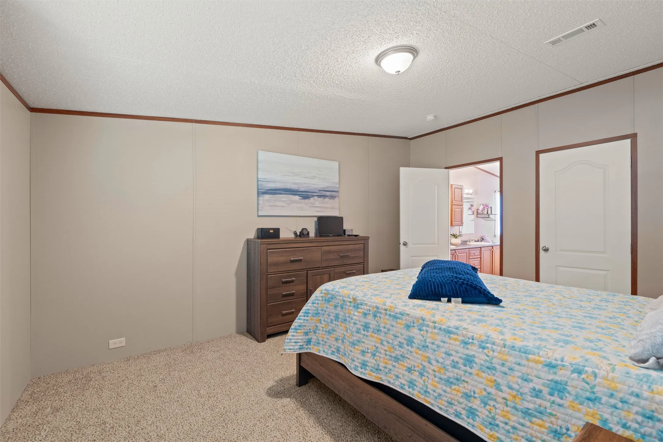 Carpeted bedroom with neutral wall panels and wood-tone trim