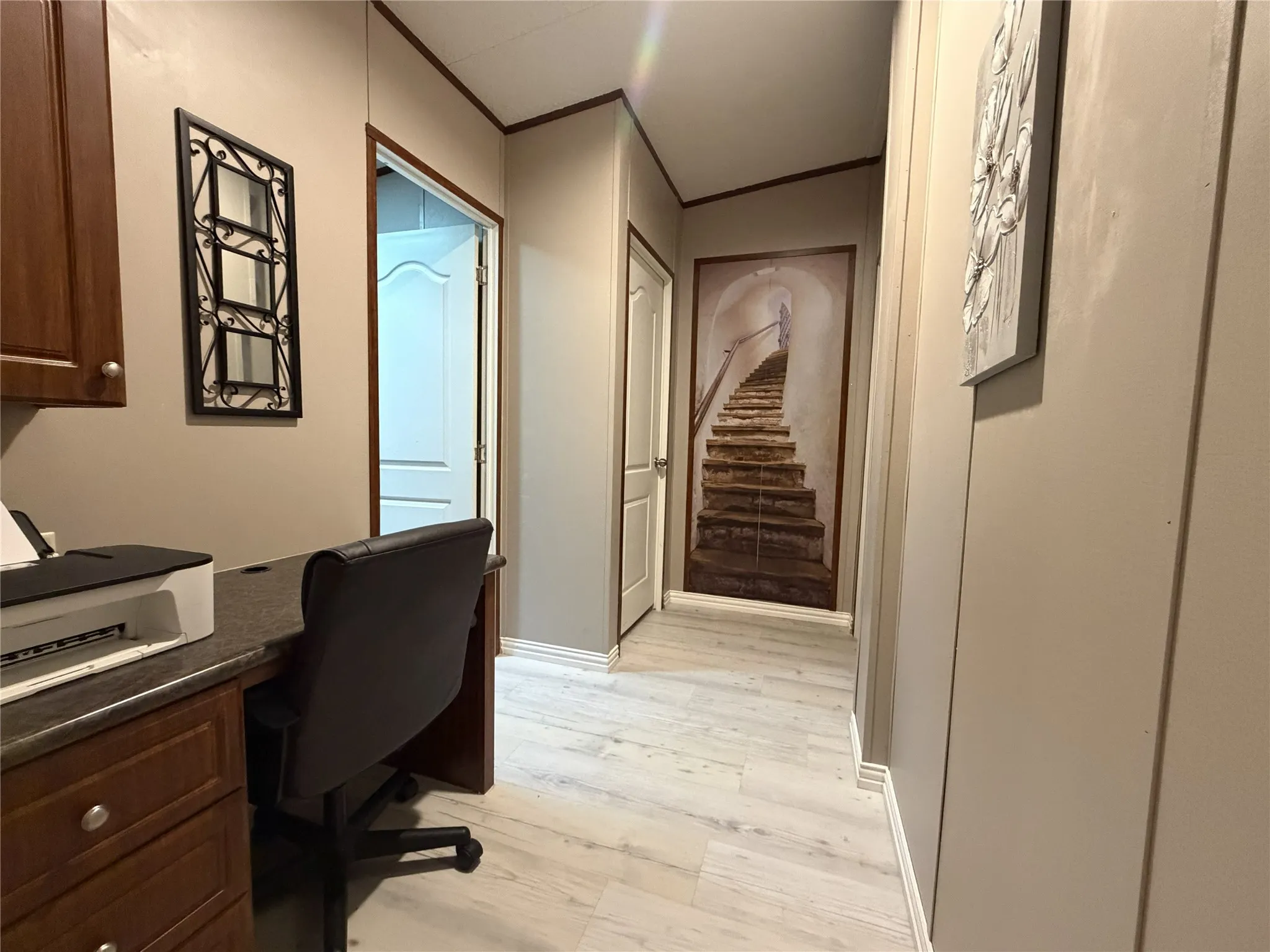 Hallway featuring wood-finish flooring, light-toned walls, and white trim