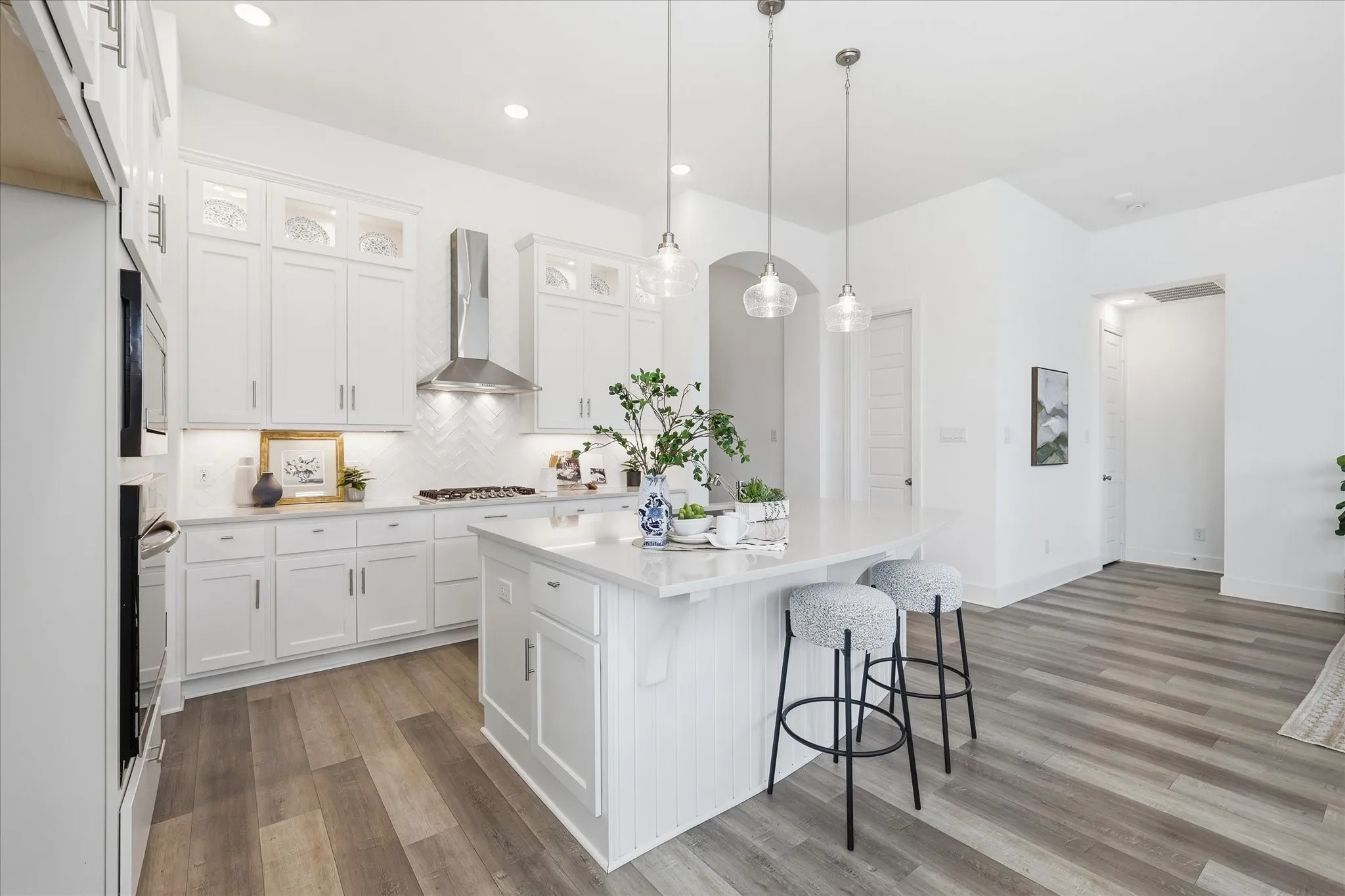 Open Concept kitchen with upgraded quartz countertops, SS gas appliances, natural lighting, and a large walk in pantry.
