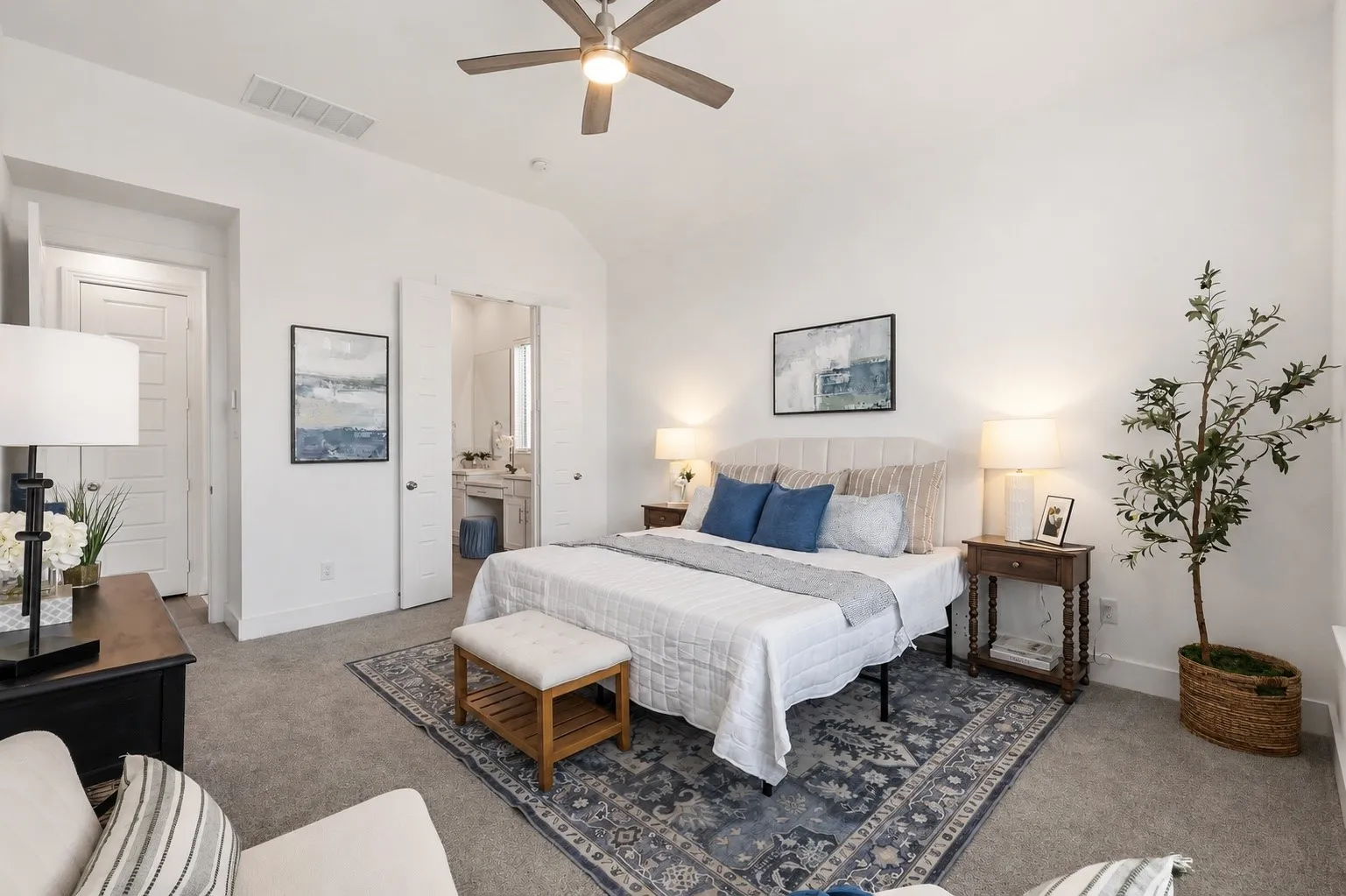 Carpeted bedroom with a vaulted ceiling, ceiling fan, and white walls