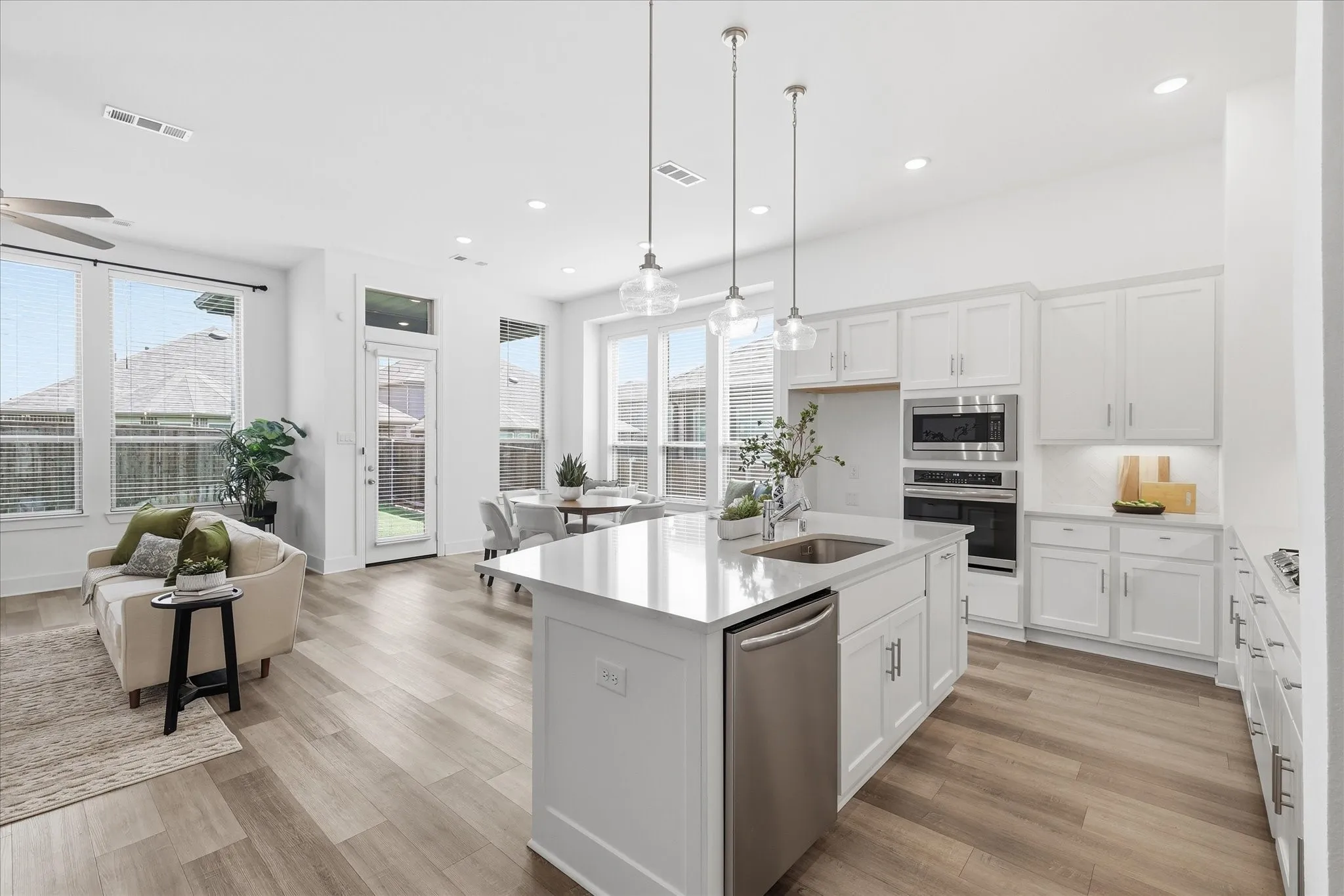 Open Concept kitchen with upgraded quartz countertops, SS gas appliances, natural lighting, and a large walk in pantry.