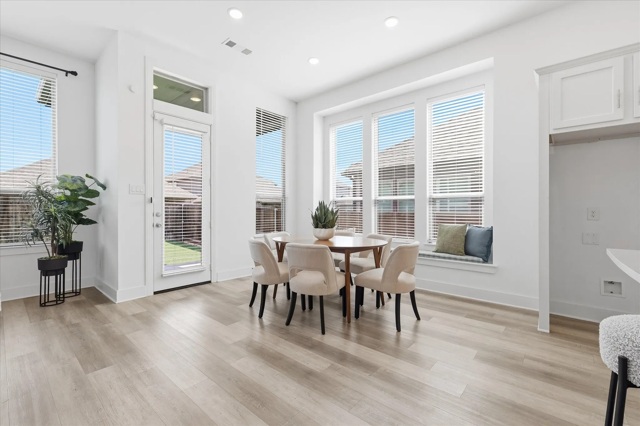 Open Concept dining area with custom bench seating, natural light and fresh paint!