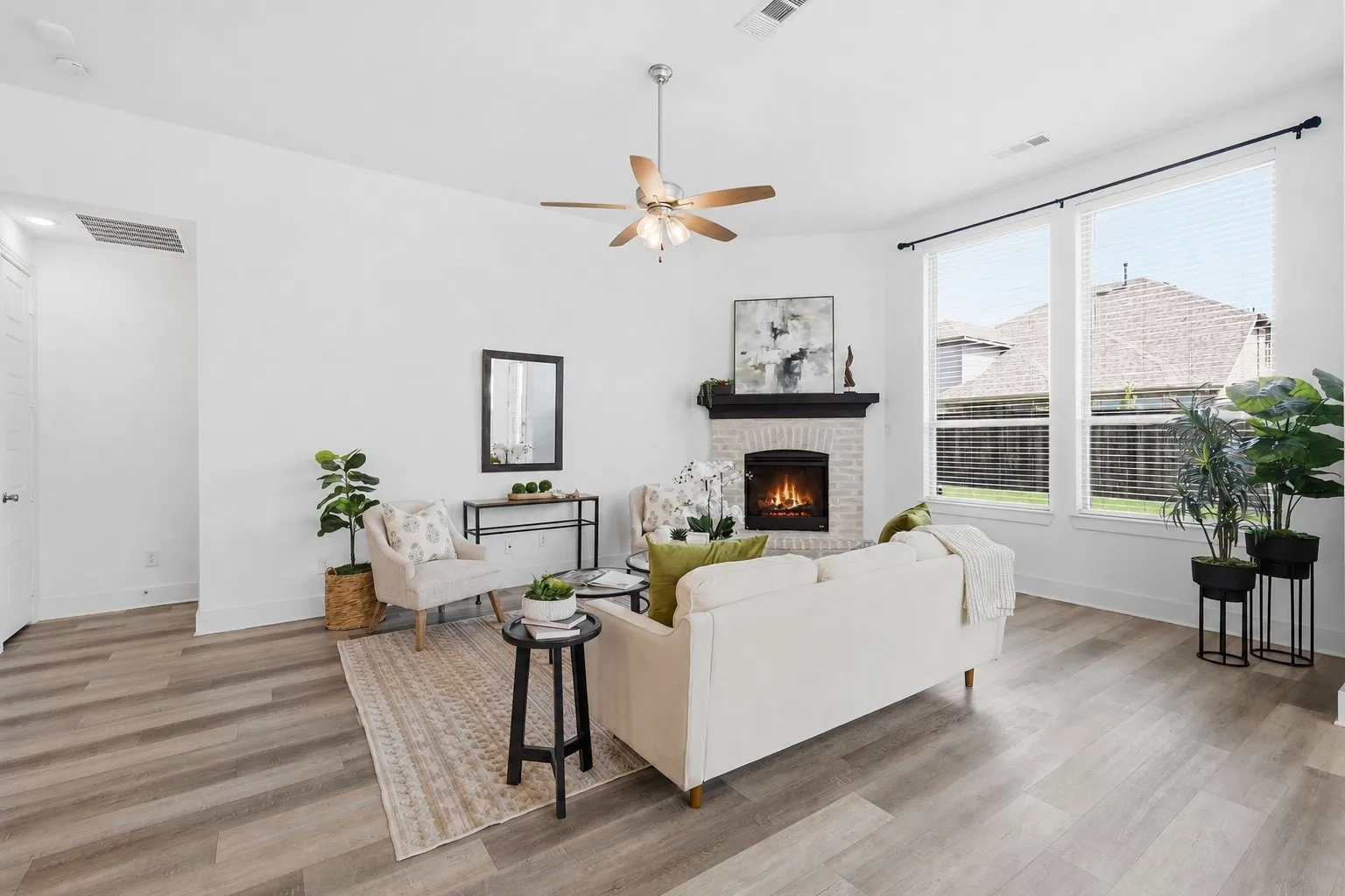 Living area with Luxury Vinyl flooring, natural light galore, gas fireplace and more!