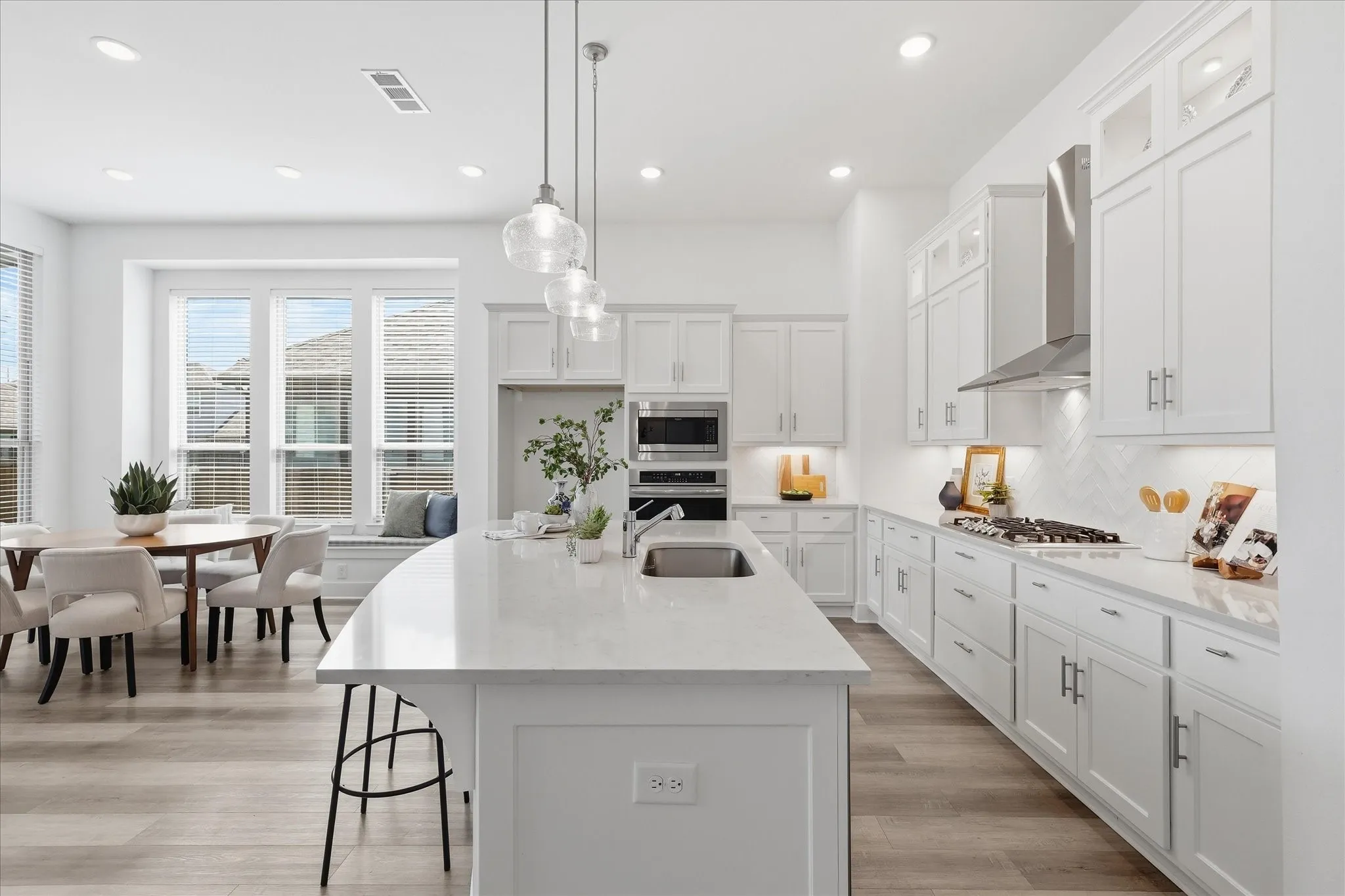 Open Concept kitchen with upgraded quartz countertops, SS gas appliances, natural lighting, and a large walk in pantry.