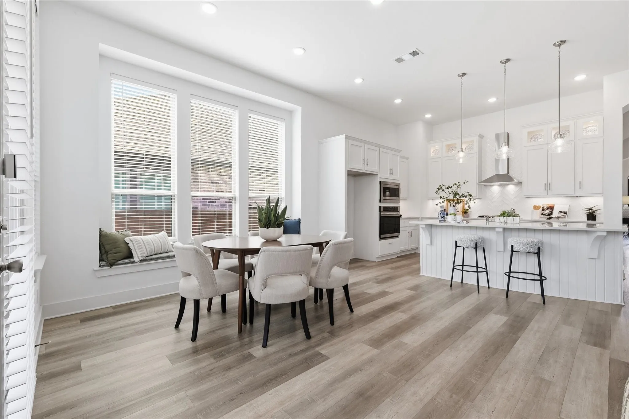 Open Concept dining area with custom bench seating, natural light and fresh paint!
