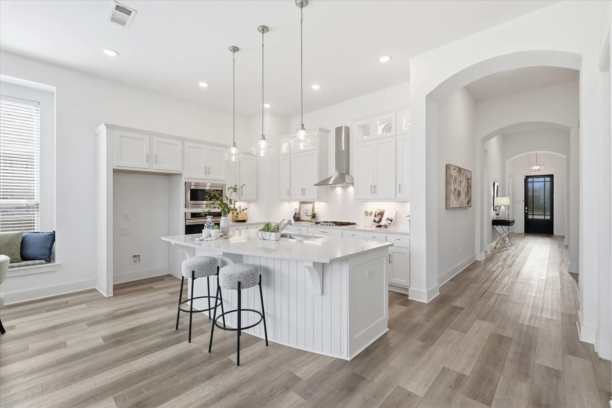 Open Concept kitchen with upgraded quartz countertops, SS gas appliances, natural lighting, and a large walk in pantry.