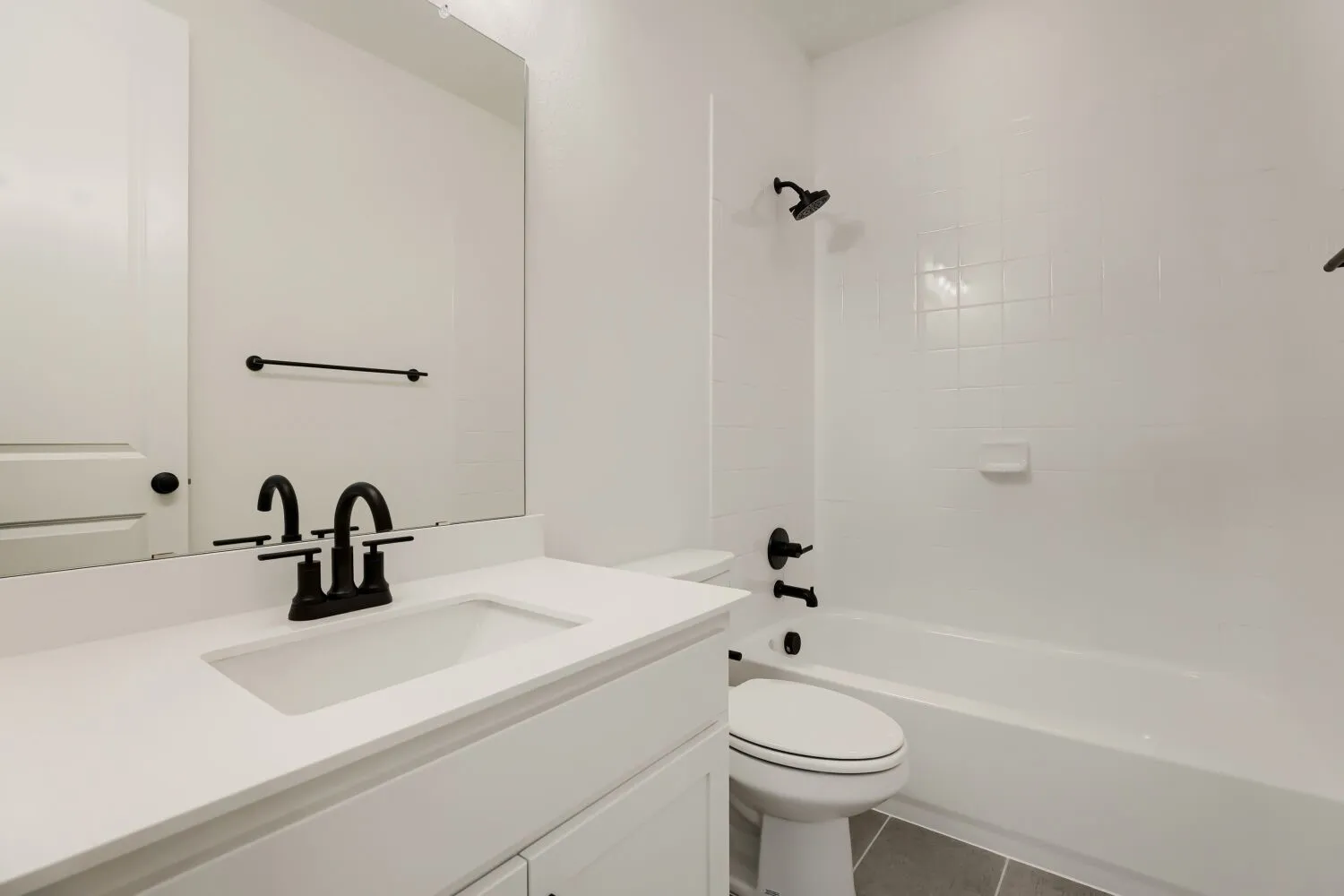 White vanity with integrated rectangular sink and matte black faucet