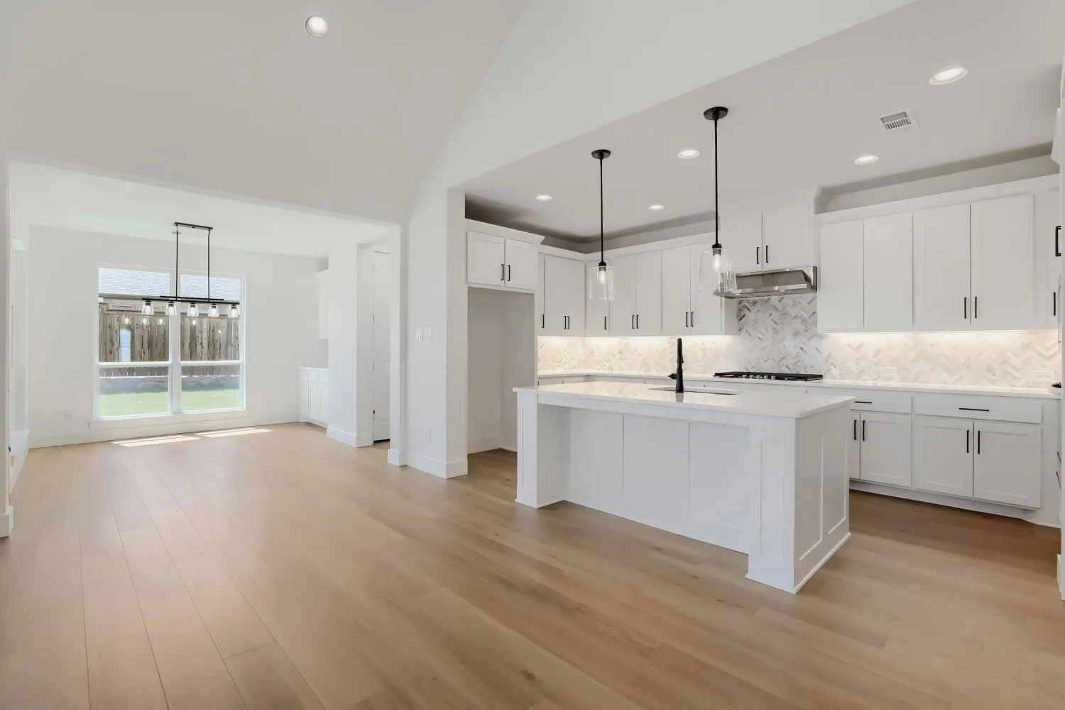 Open-concept kitchen and dining area with light wood-finish flooring