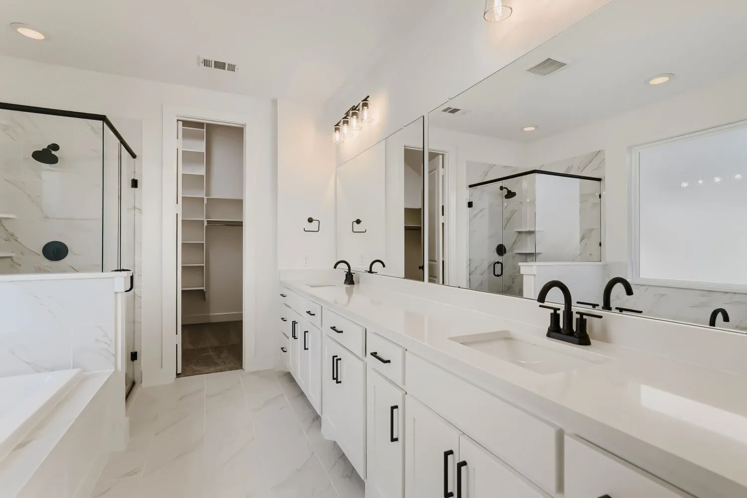 Double vanity with undermount sinks, white cabinetry, and matte black fixtures