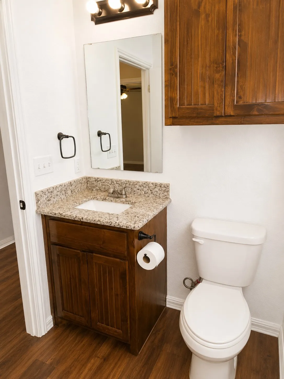 Bathroom featuring a dark wood-finish vanity with a granite countertop and integrated sink