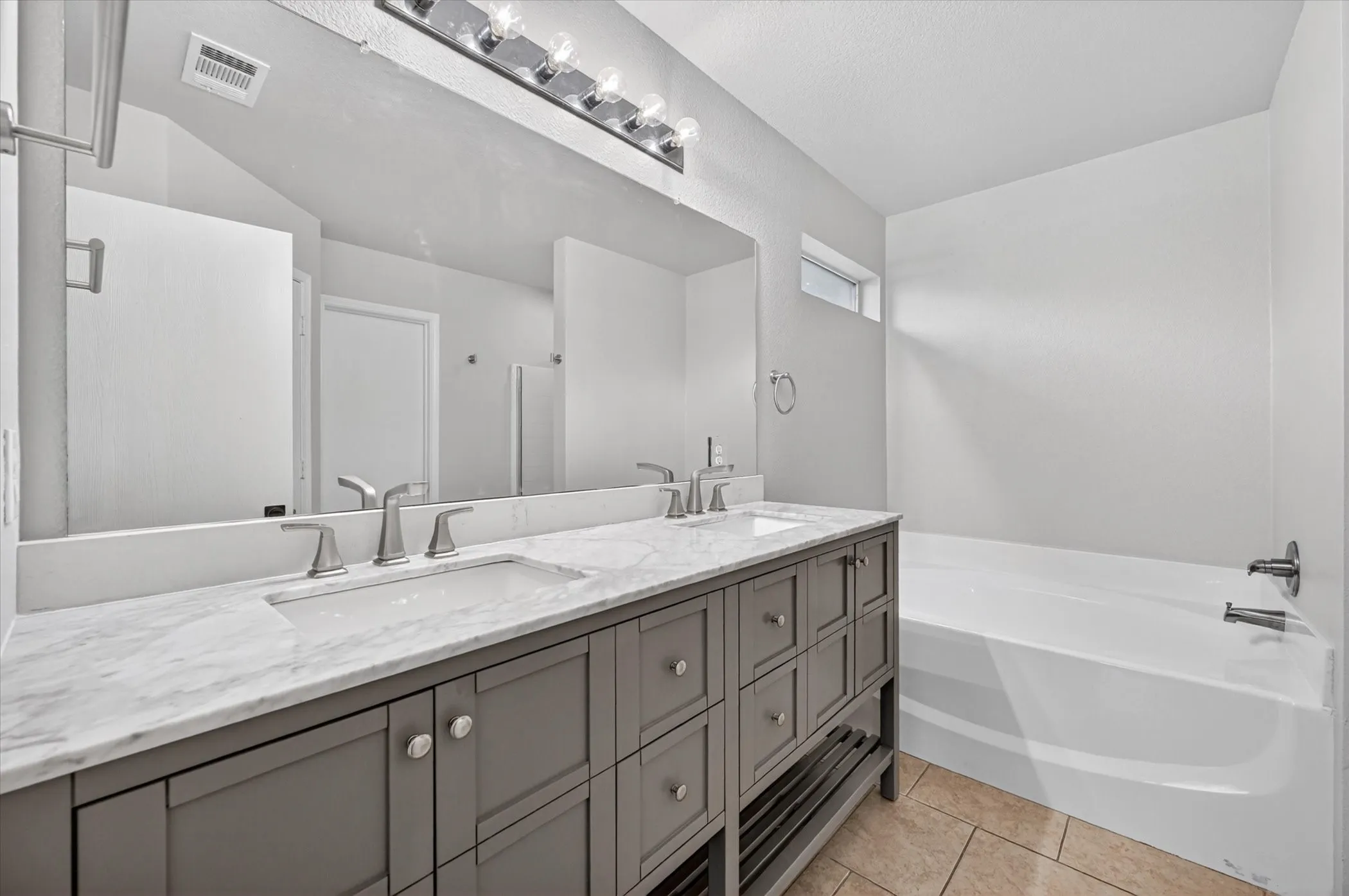 Dual vanity featuring a stone countertop with integrated sinks and brushed nickel fixtures